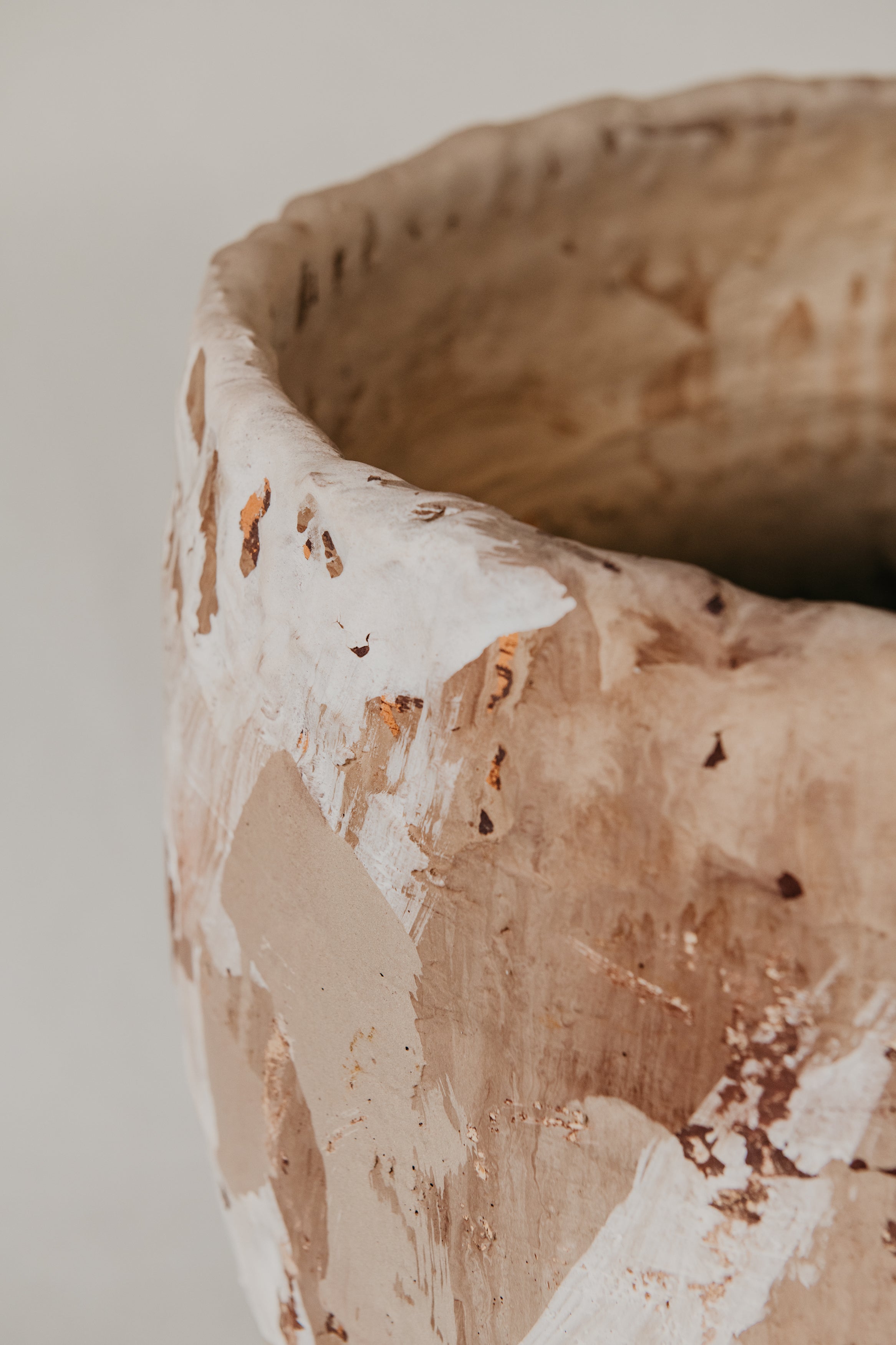 Close-up of a textured ceramic pot with a neutral background