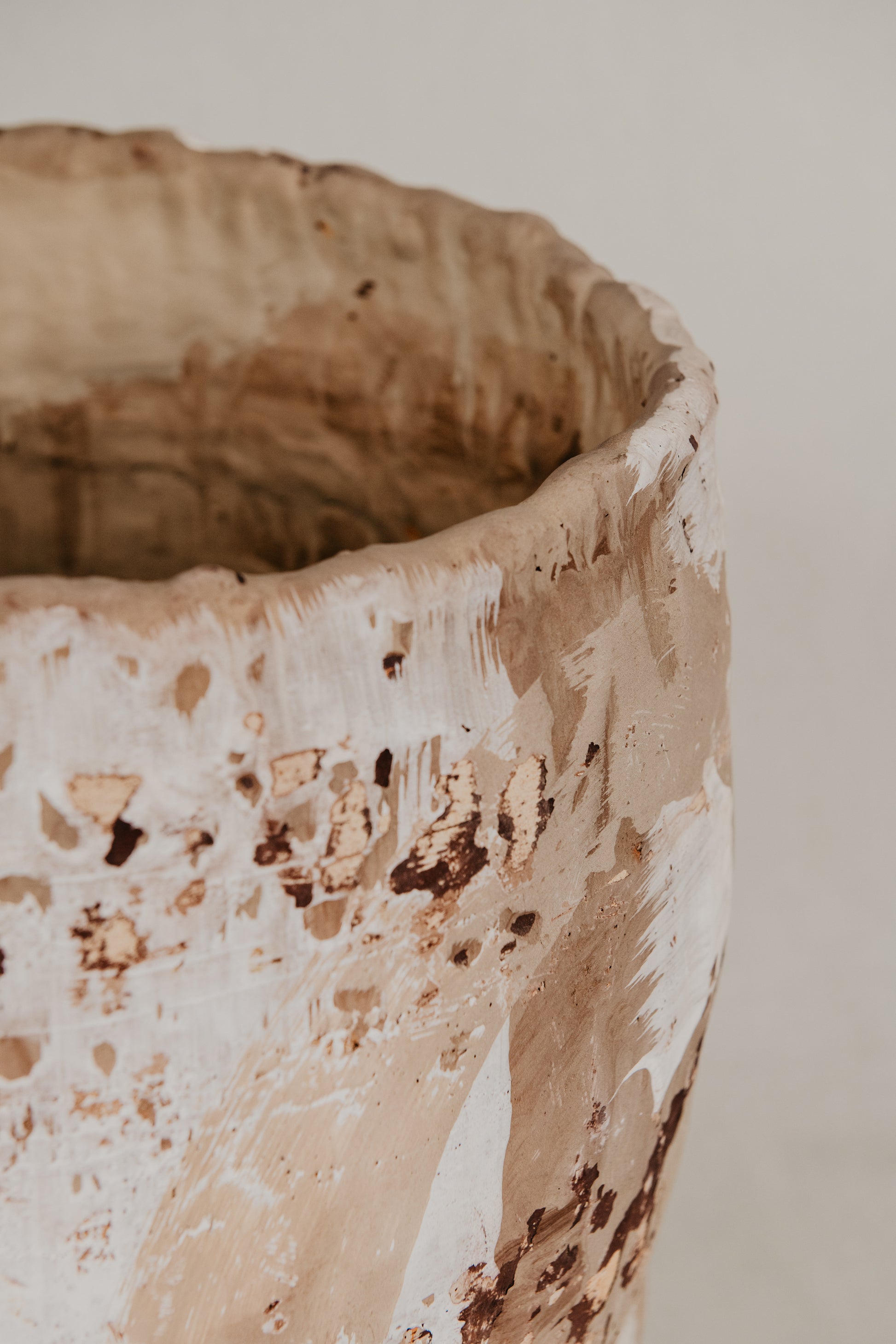 Close-up of a textured ceramic pot on a neutral background