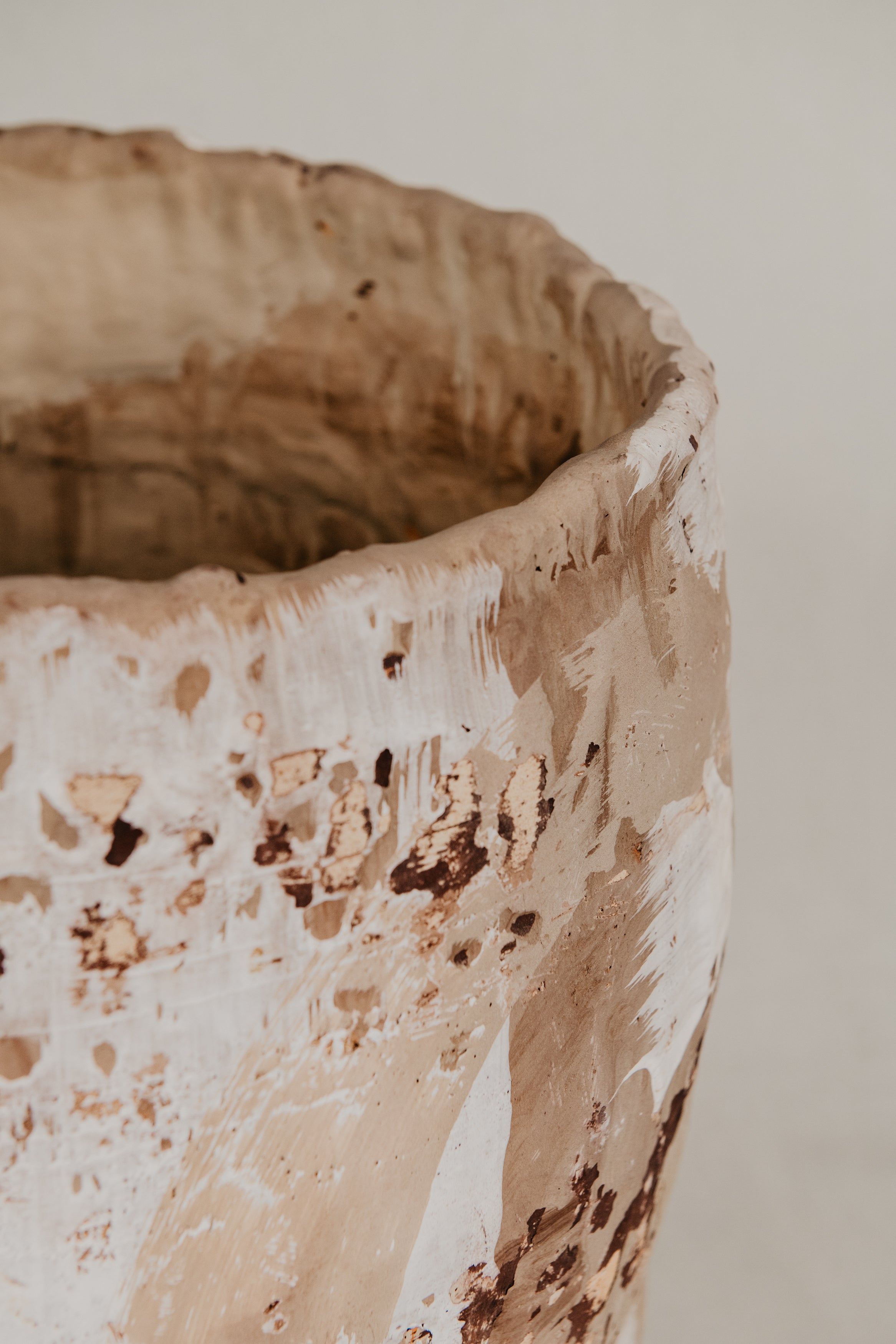 Close-up of a textured ceramic pot on a neutral background