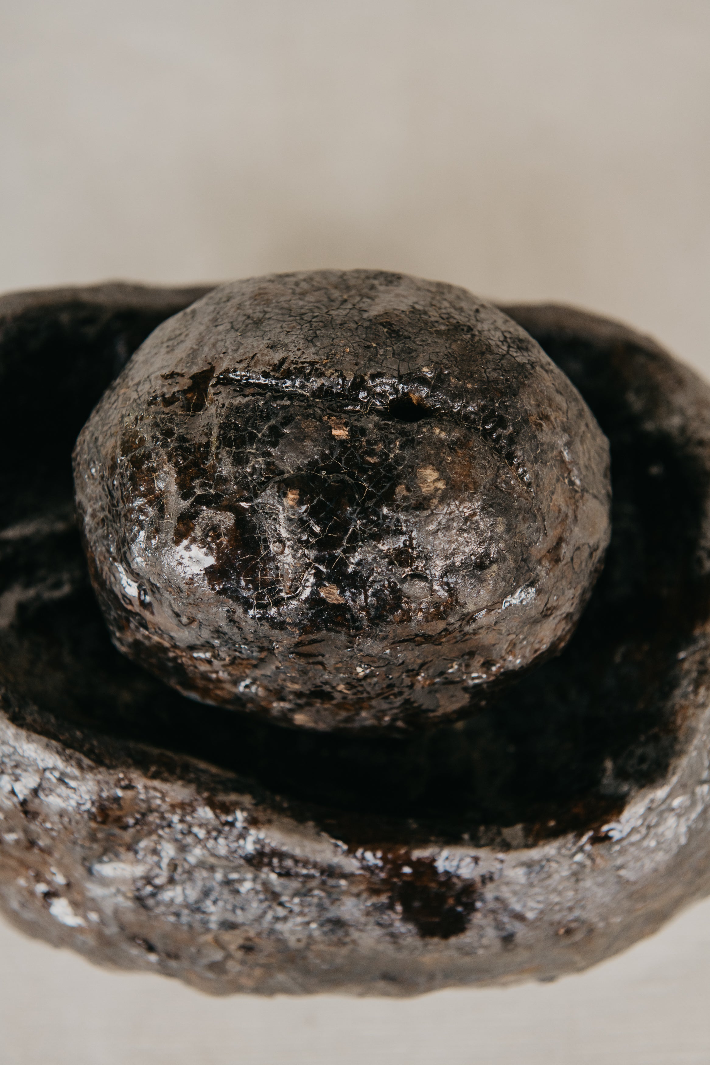 Close-up of a textured stone object on a plain background