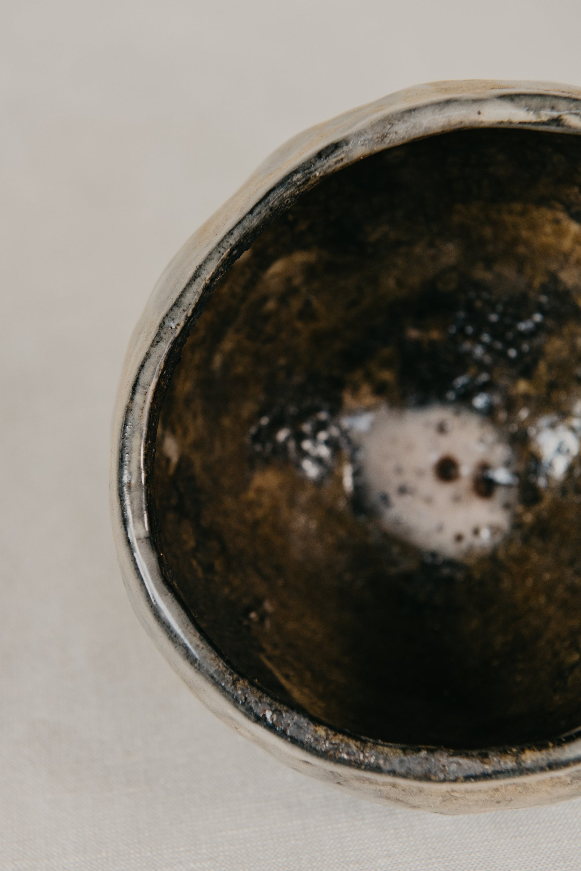 Close-up of a ceramic bowl with a textured interior on a neutral background