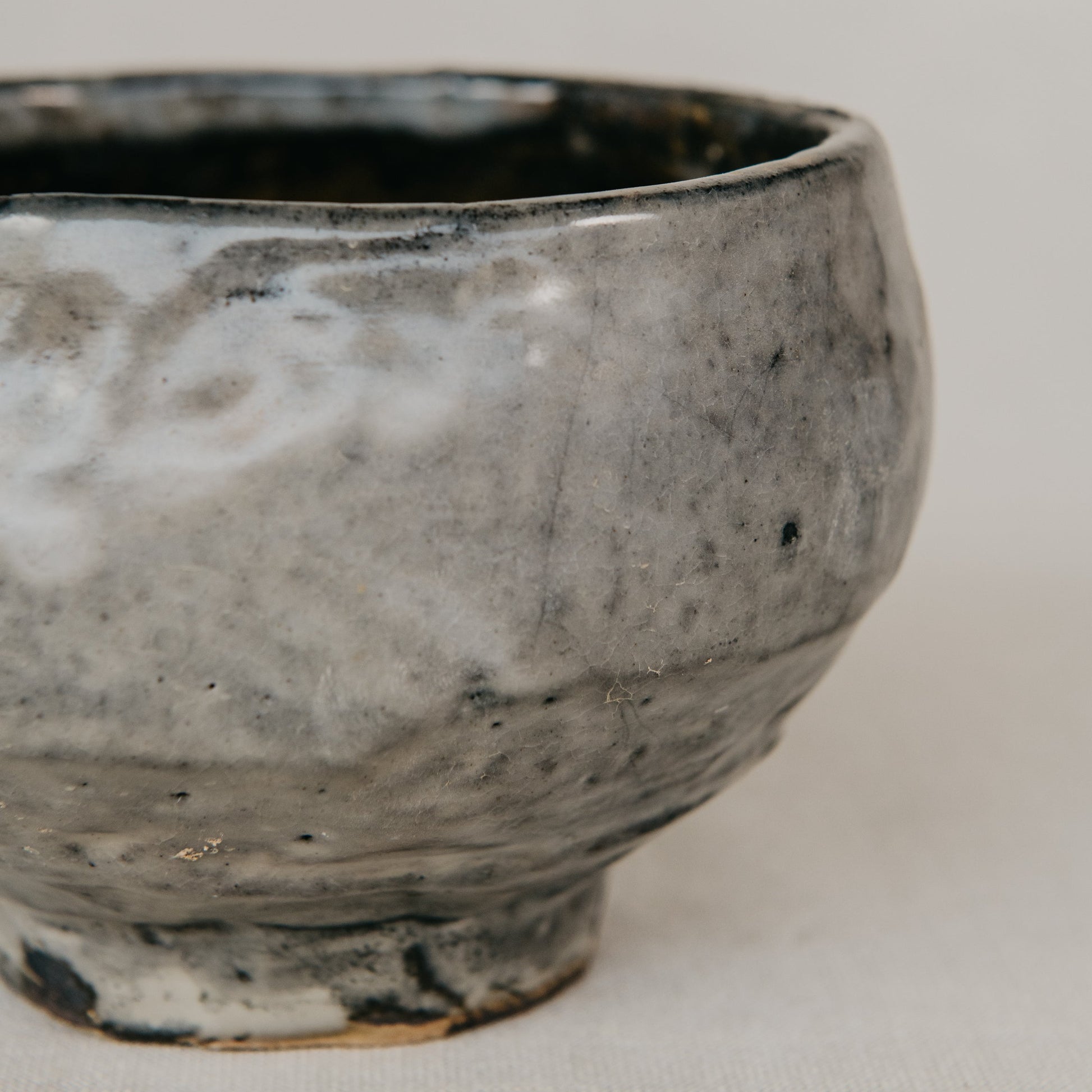 Handmade ceramic bowl with a textured surface on a plain background