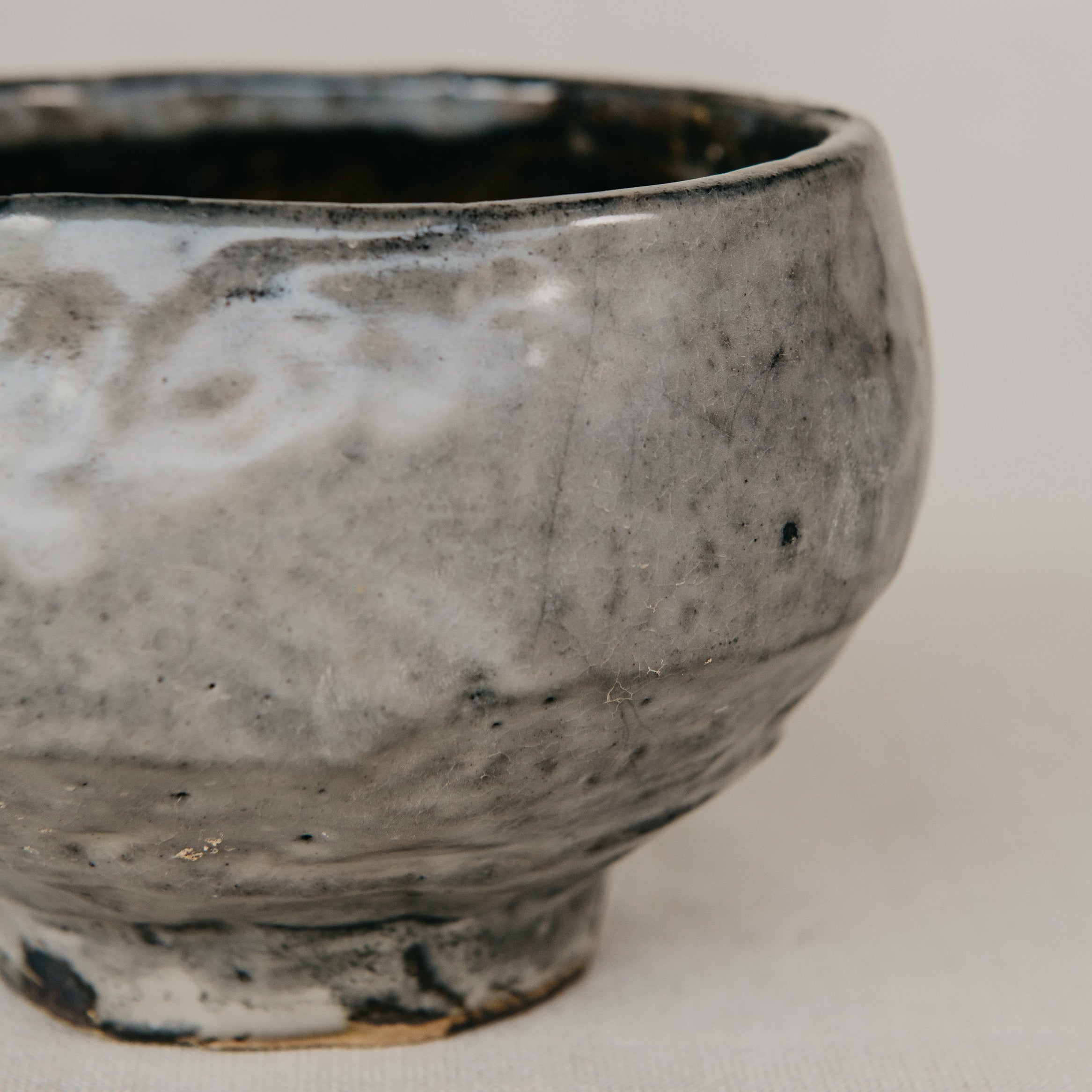 Handmade ceramic bowl with a textured surface on a plain background