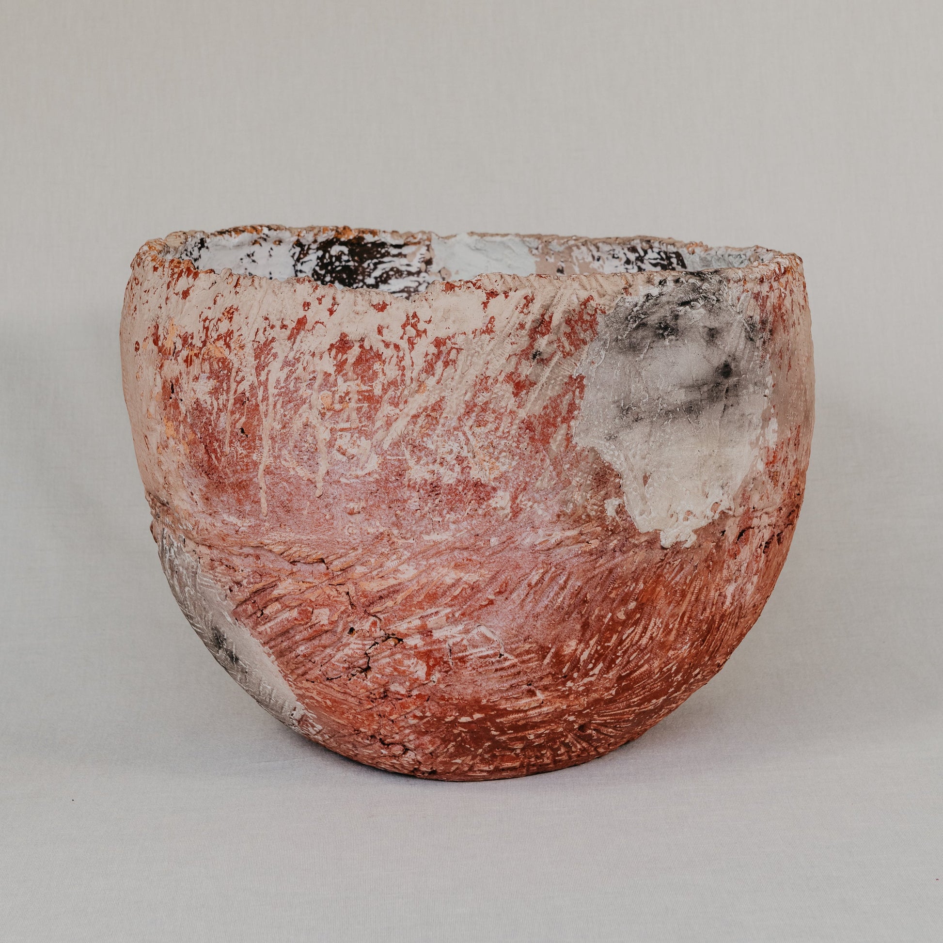 Ceramic pot with a textured surface on a plain background