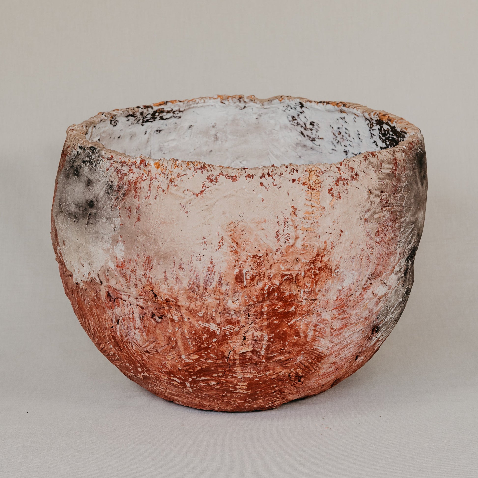 Ceramic pot with a textured surface on a plain background