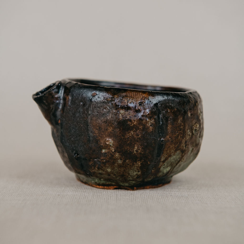Black ceramic teapot on a beige background