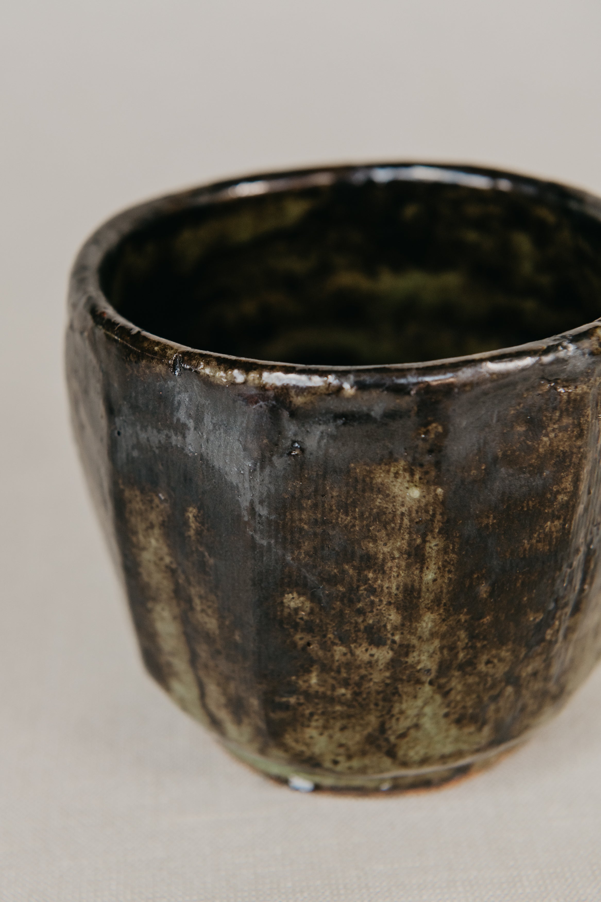 Black ceramic cup with a textured surface on a light gray background