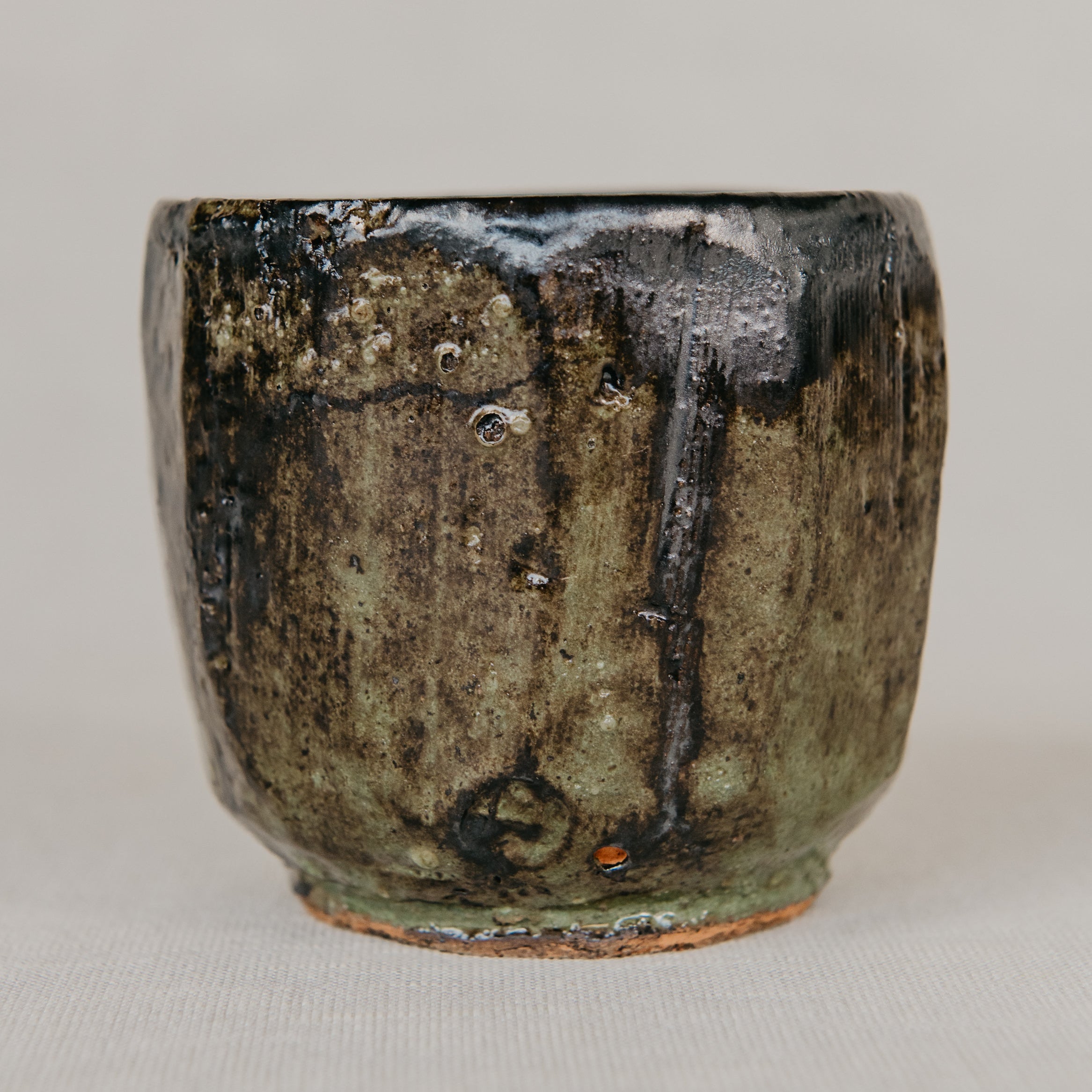 Stoneware cup with a textured surface on a plain background