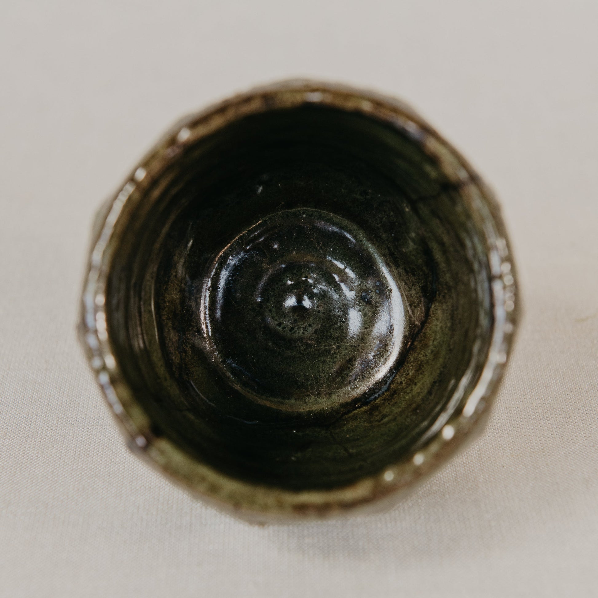 Close-up of a dark ceramic vase on a light background