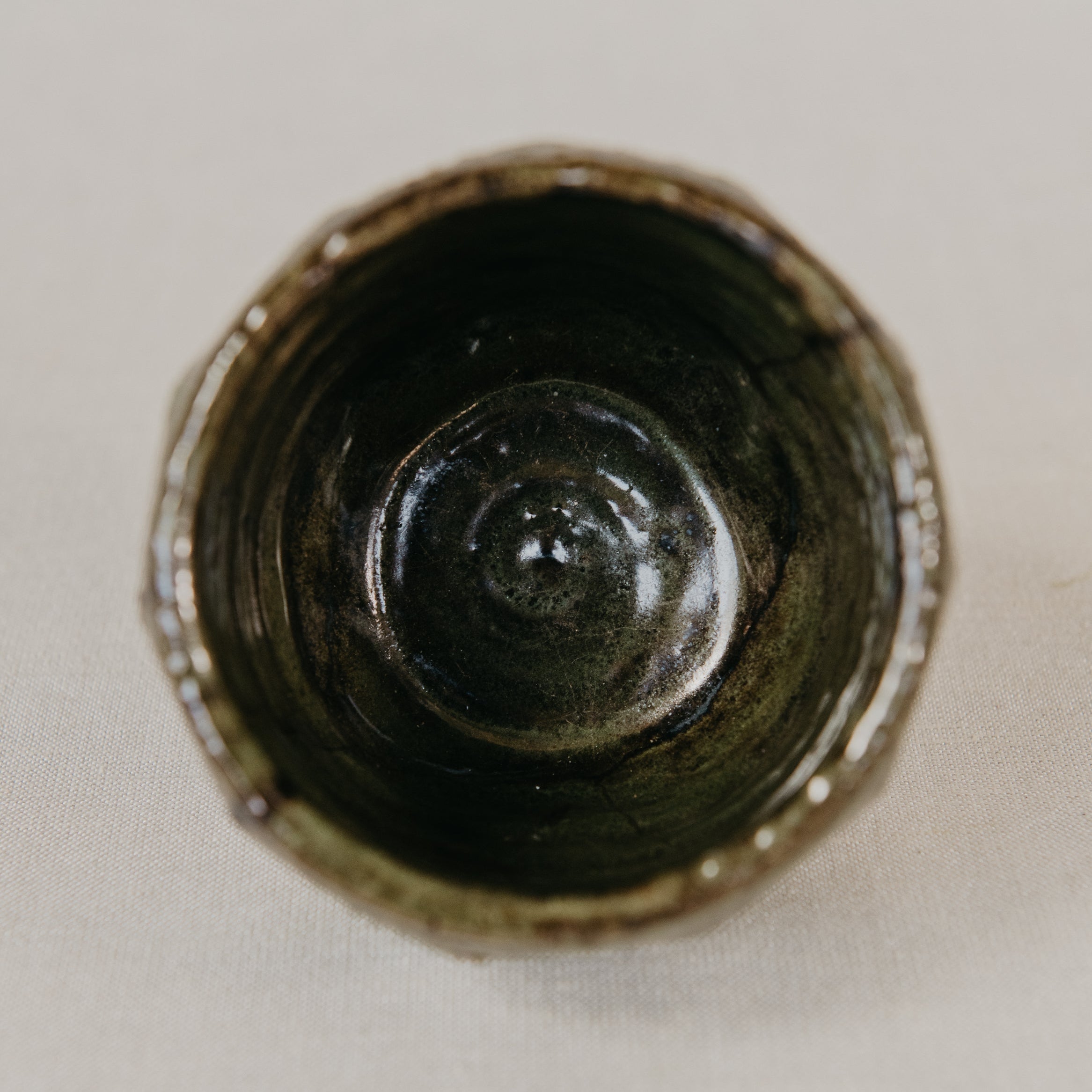 Close-up of a dark ceramic vase on a light background