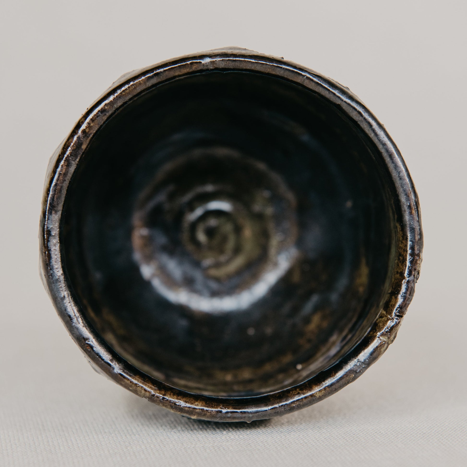 Black ceramic bowl with a spiral pattern on a gray background