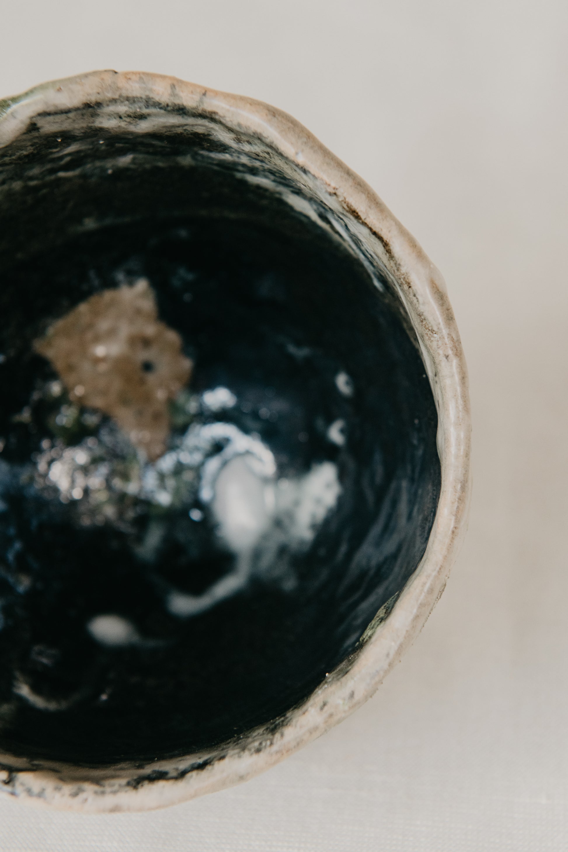 Close-up of a ceramic bowl with a textured interior on a neutral background
