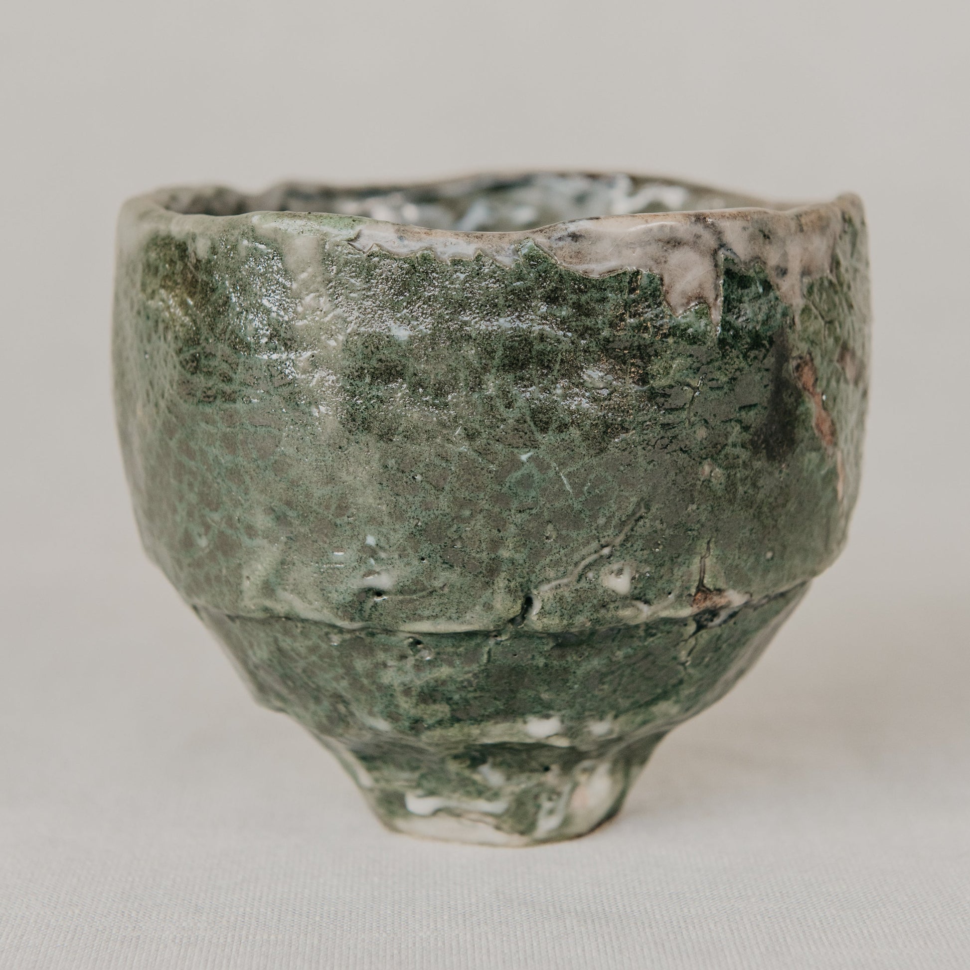 Green ceramic cup on a light gray background