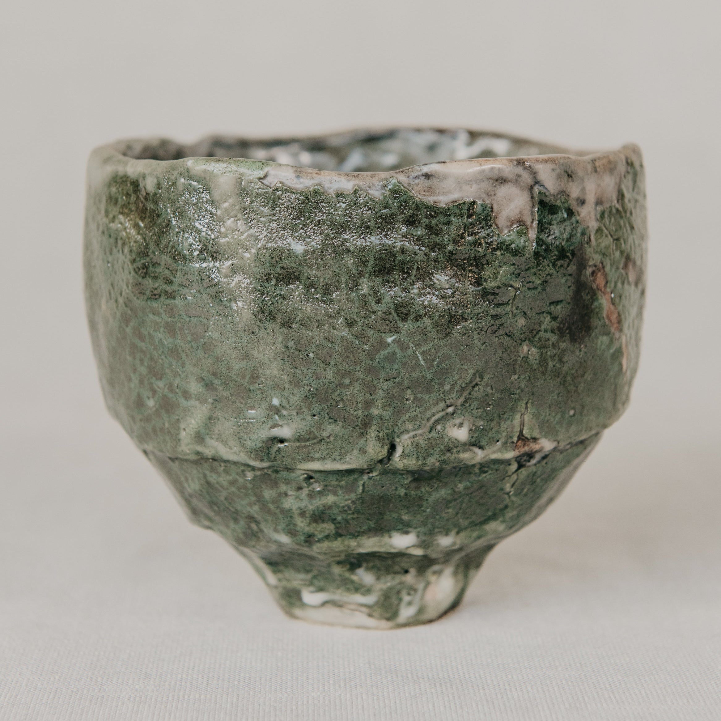 Green ceramic cup on a light gray background