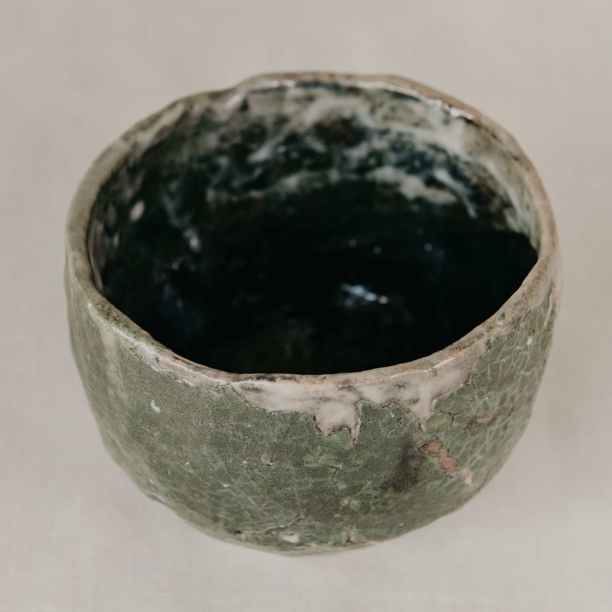 Green ceramic cup on a light gray background