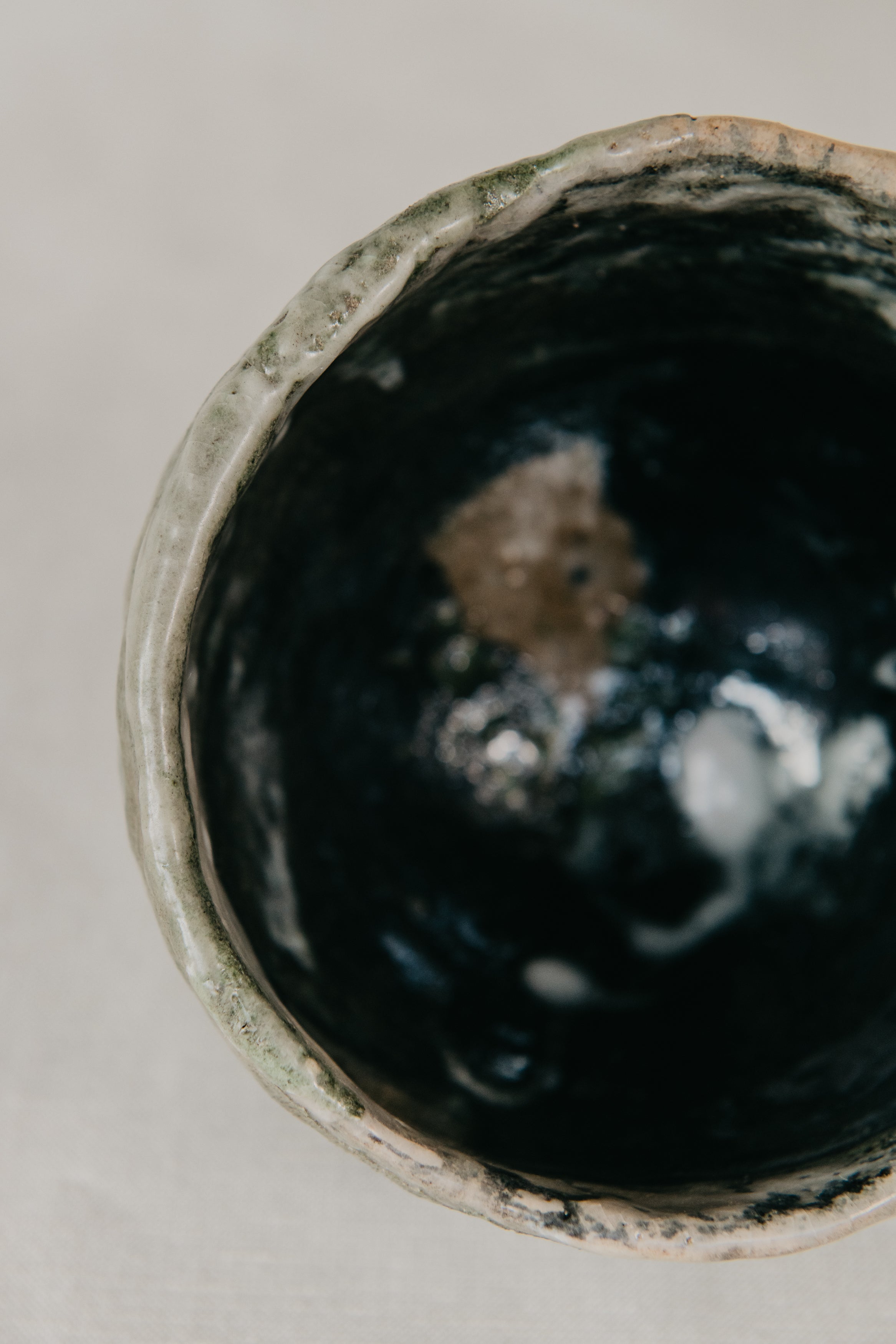 Close-up of a ceramic pot with a textured interior on a neutral background