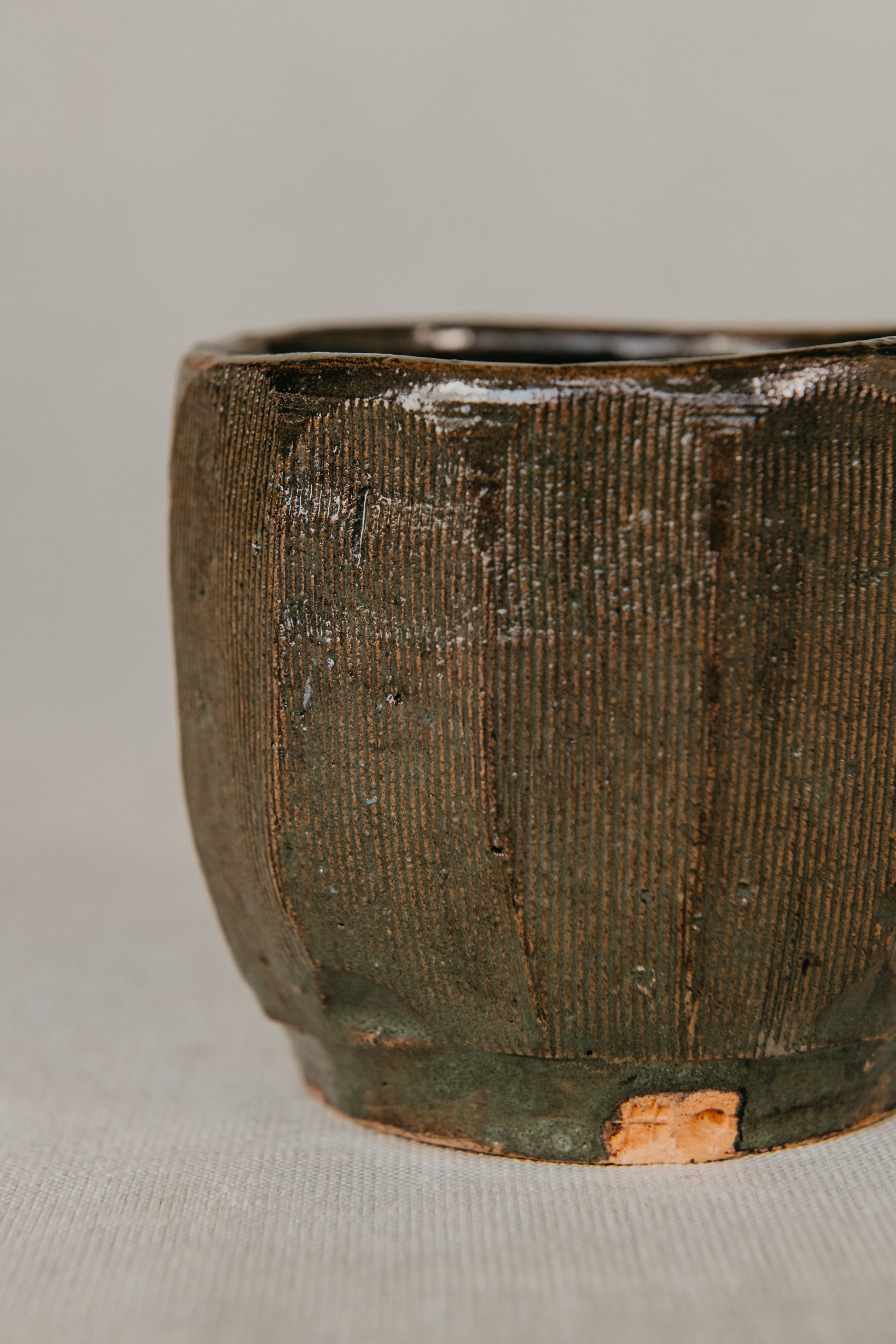 Textured ceramic cup on a neutral background