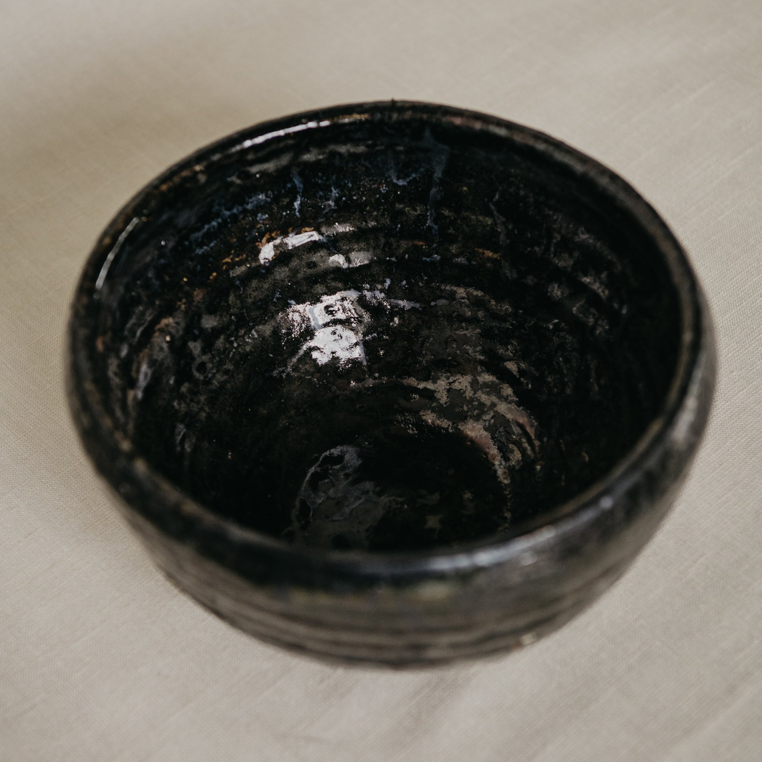 Black ceramic bowl on a light wooden surface