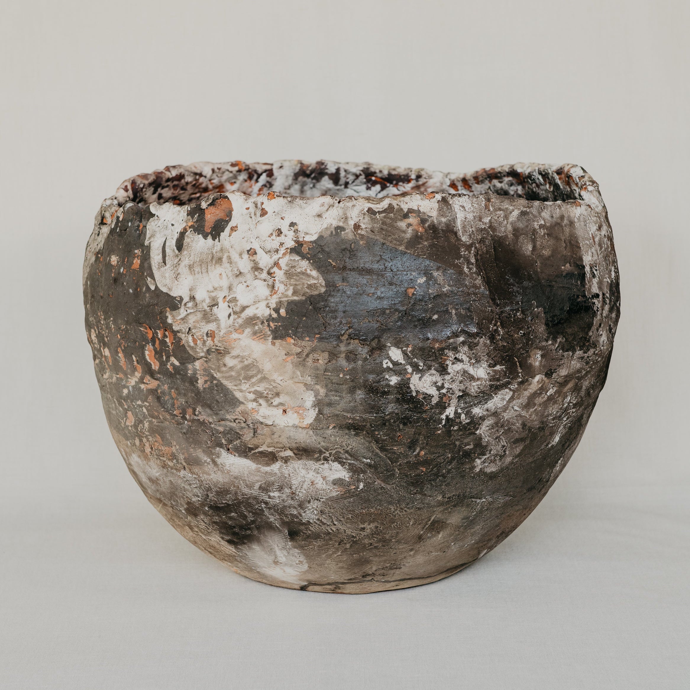 Vintage ceramic pot with a textured surface on a plain background