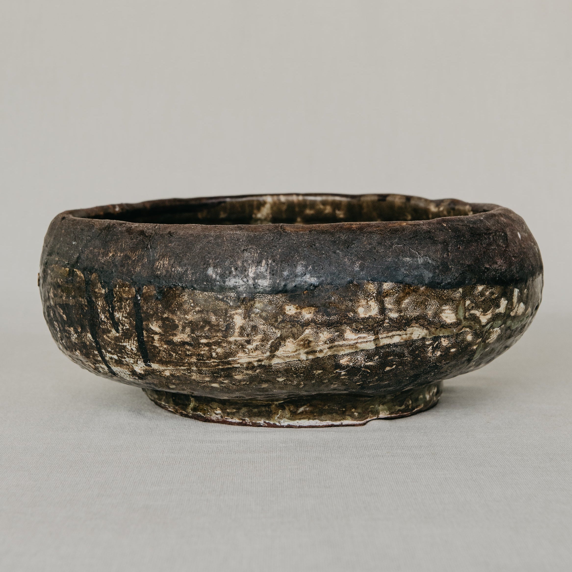 Vintage ceramic bowl with a textured surface on a plain background
