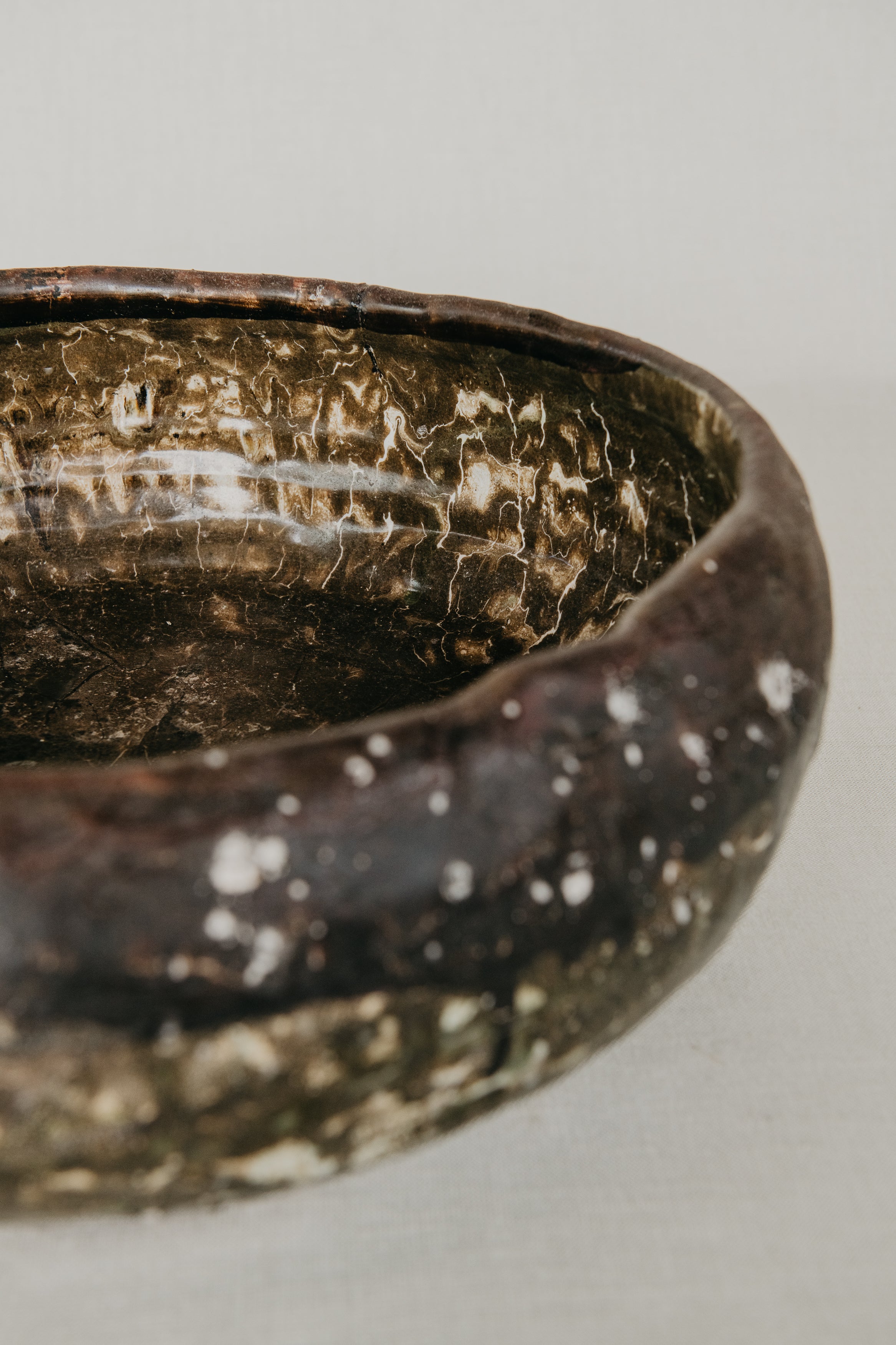 Close-up of a textured ceramic bowl on a light gray background