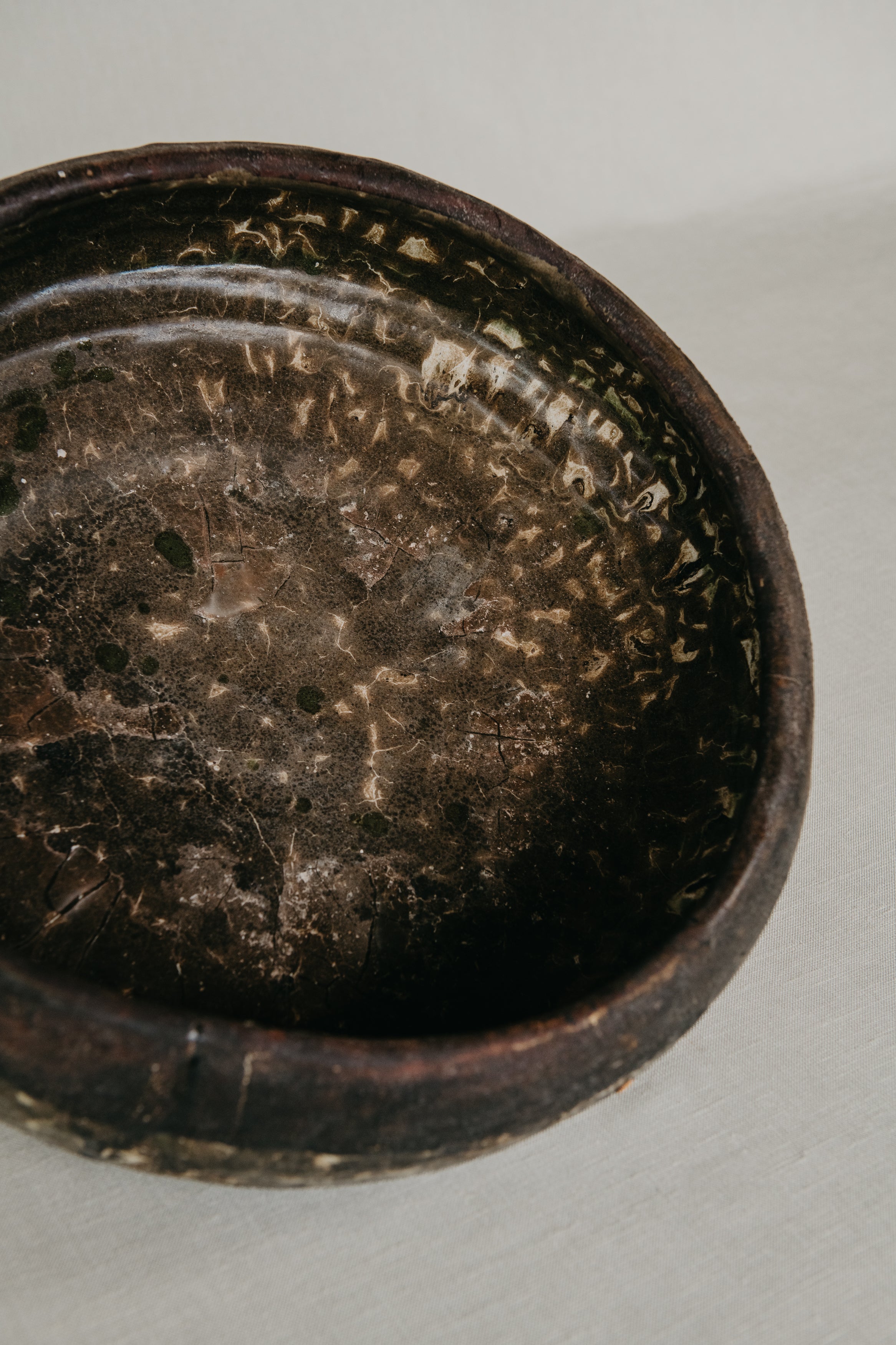 Close-up of a dark brown ceramic bowl on a light gray background