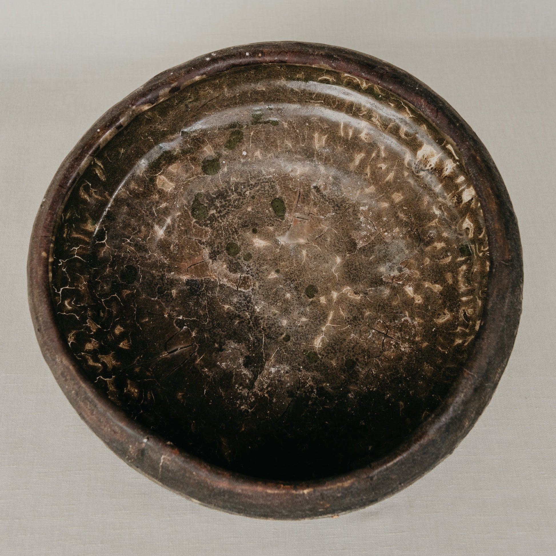 Dark brown ceramic bowl on a light gray background