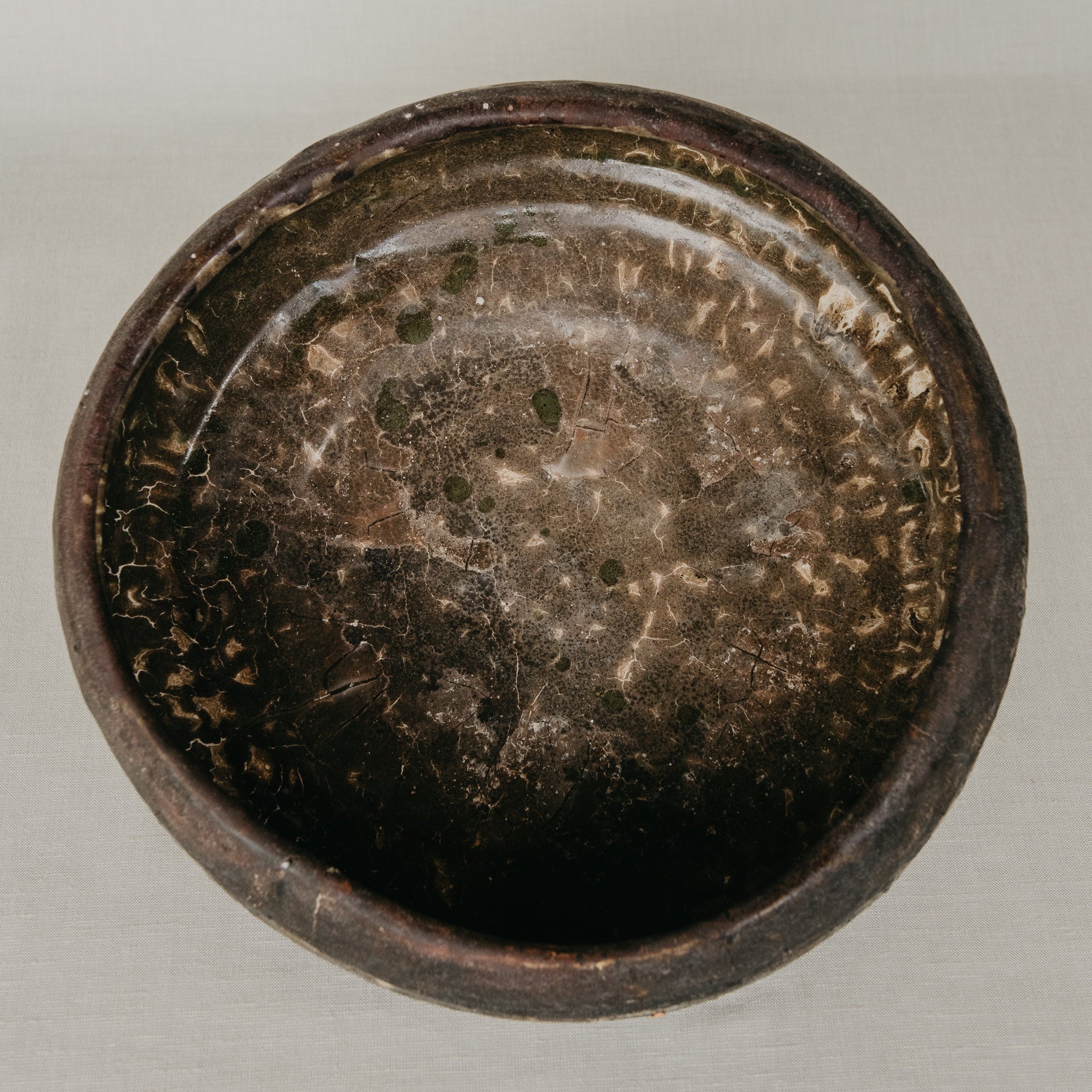 Dark brown ceramic bowl on a light gray background