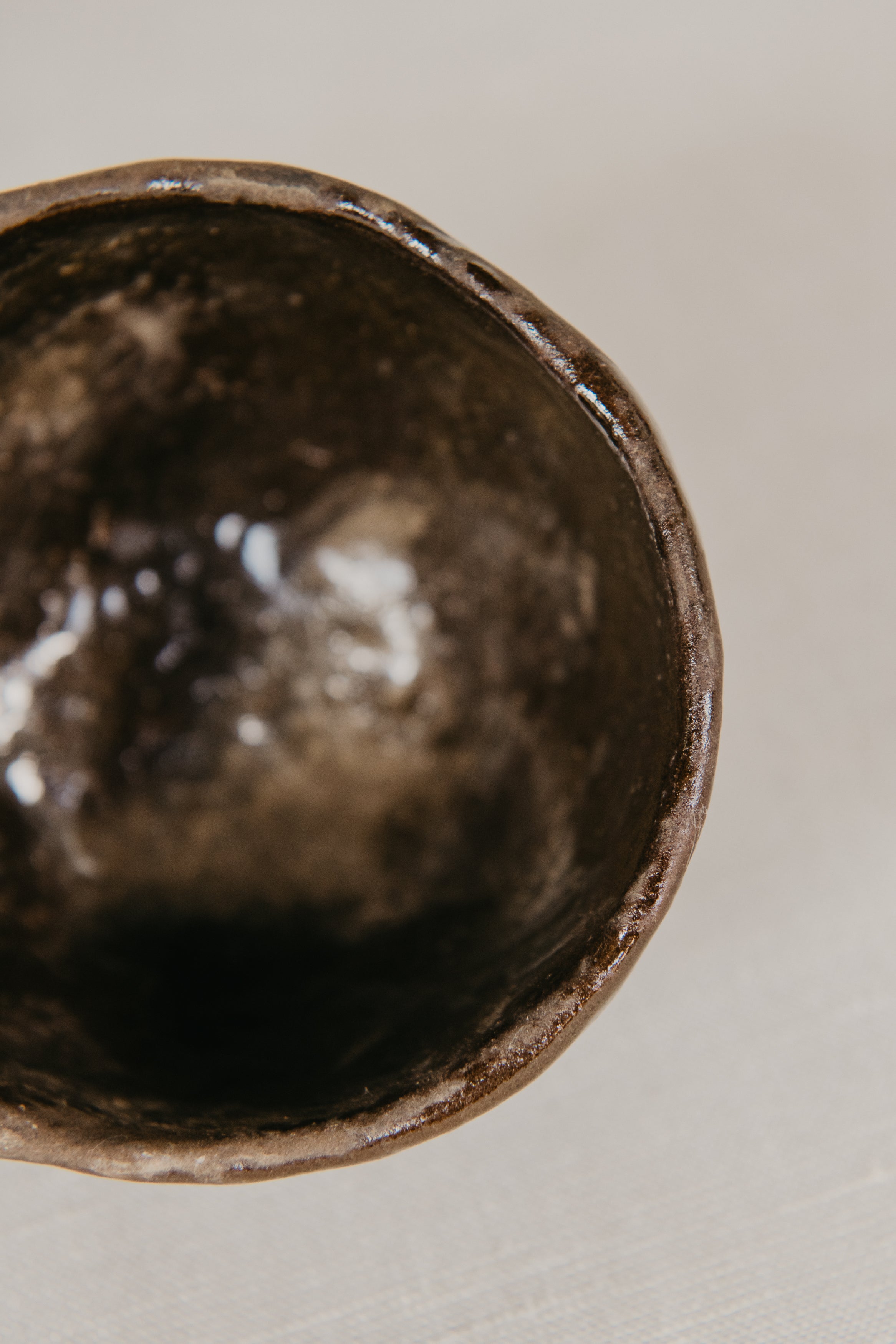 Close-up of a dark brown ceramic bowl on a light background