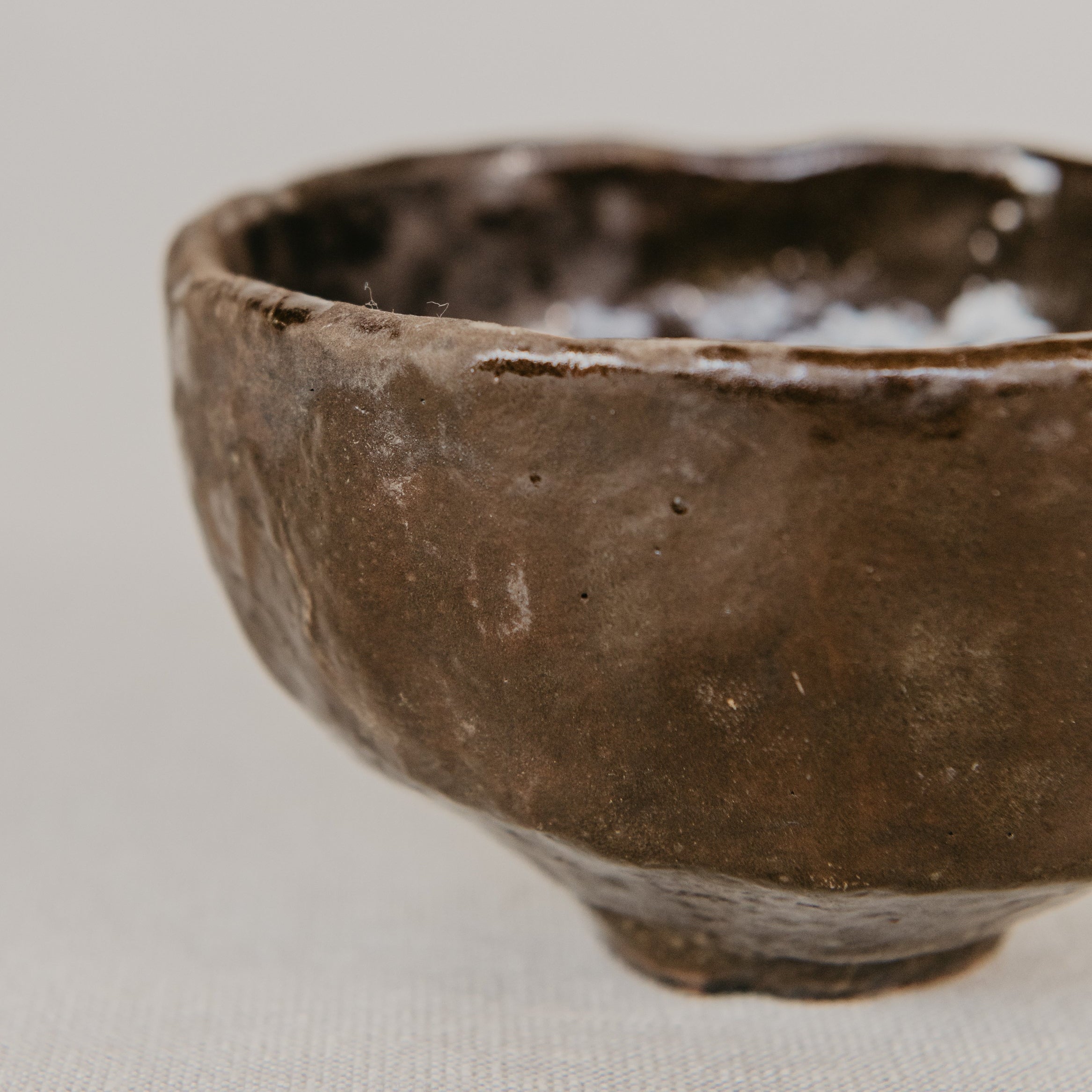 Brown ceramic bowl on a light gray background