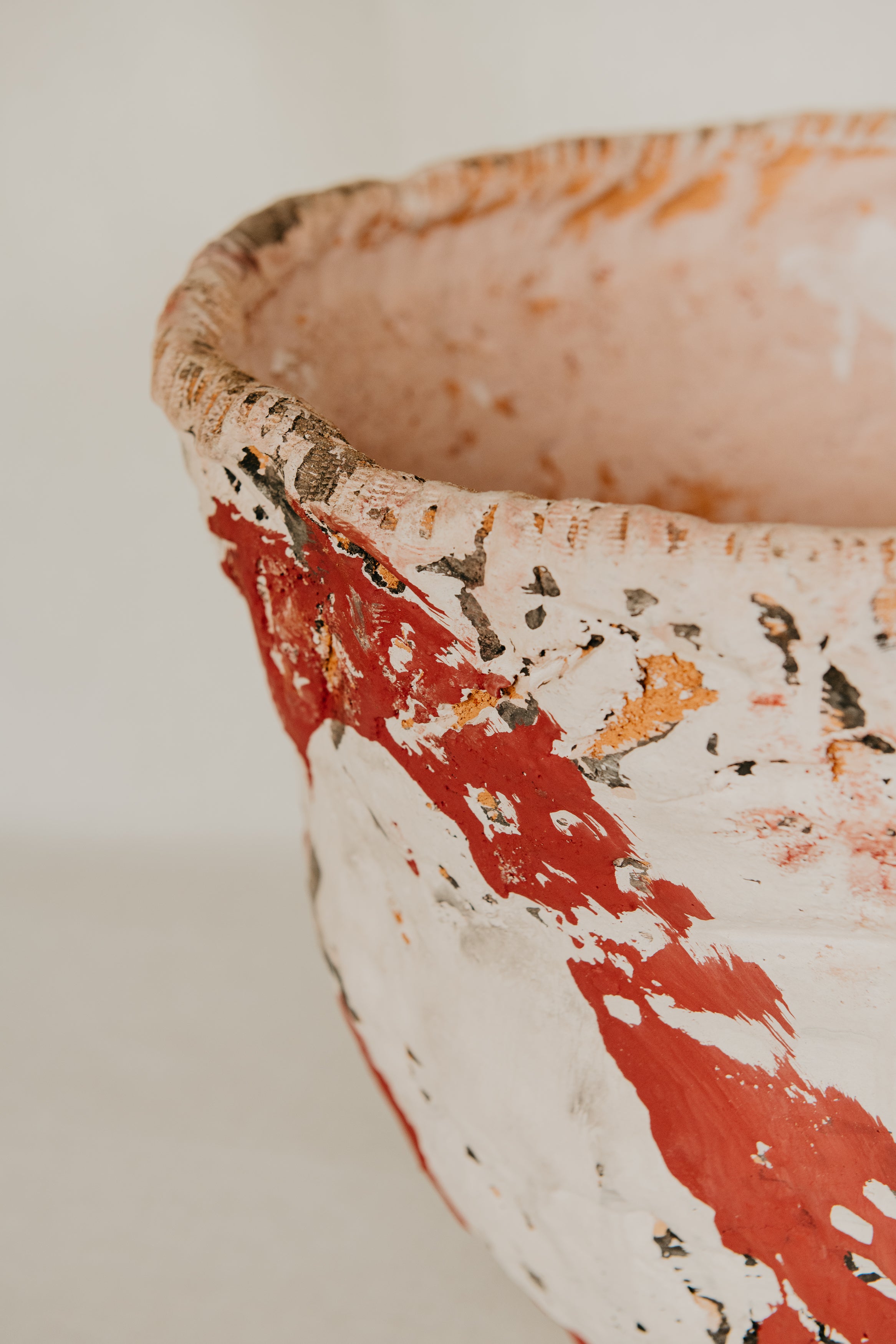 Close-up of a ceramic bowl with red and white patterns on a light background
