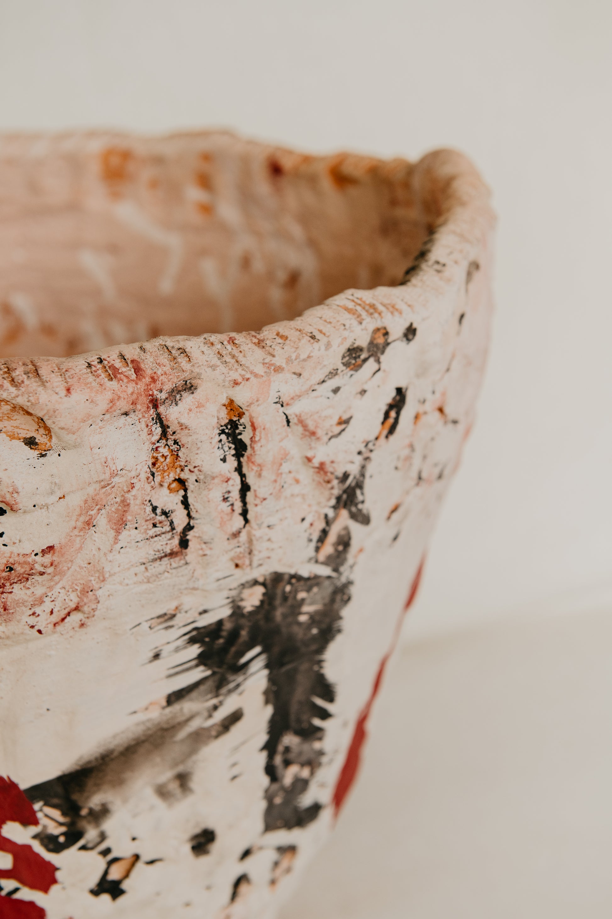 Close-up of a ceramic bowl with textured surface and floral patterns on a white background