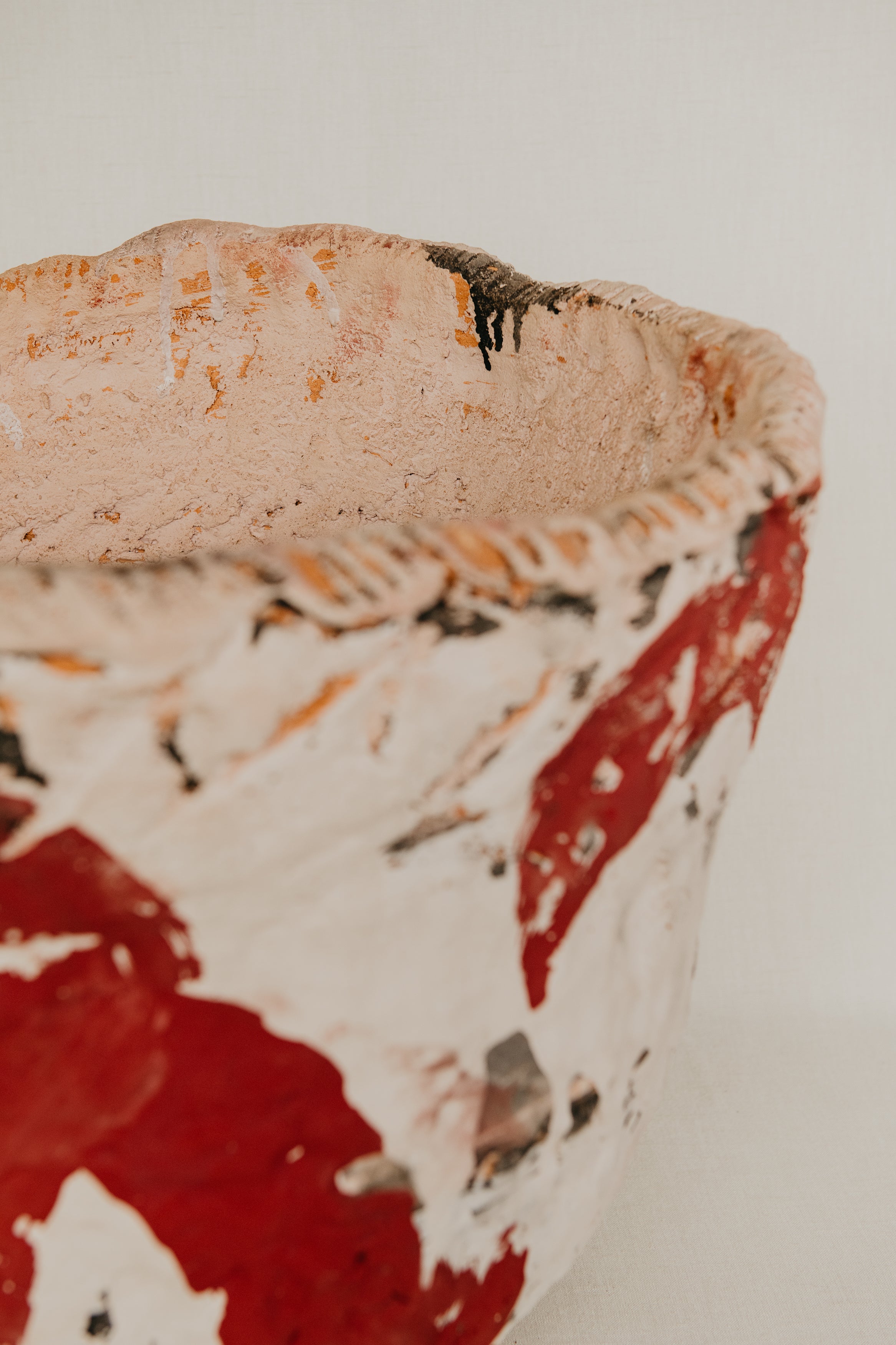 Close-up of a ceramic bowl with red and white abstract design on a neutral background