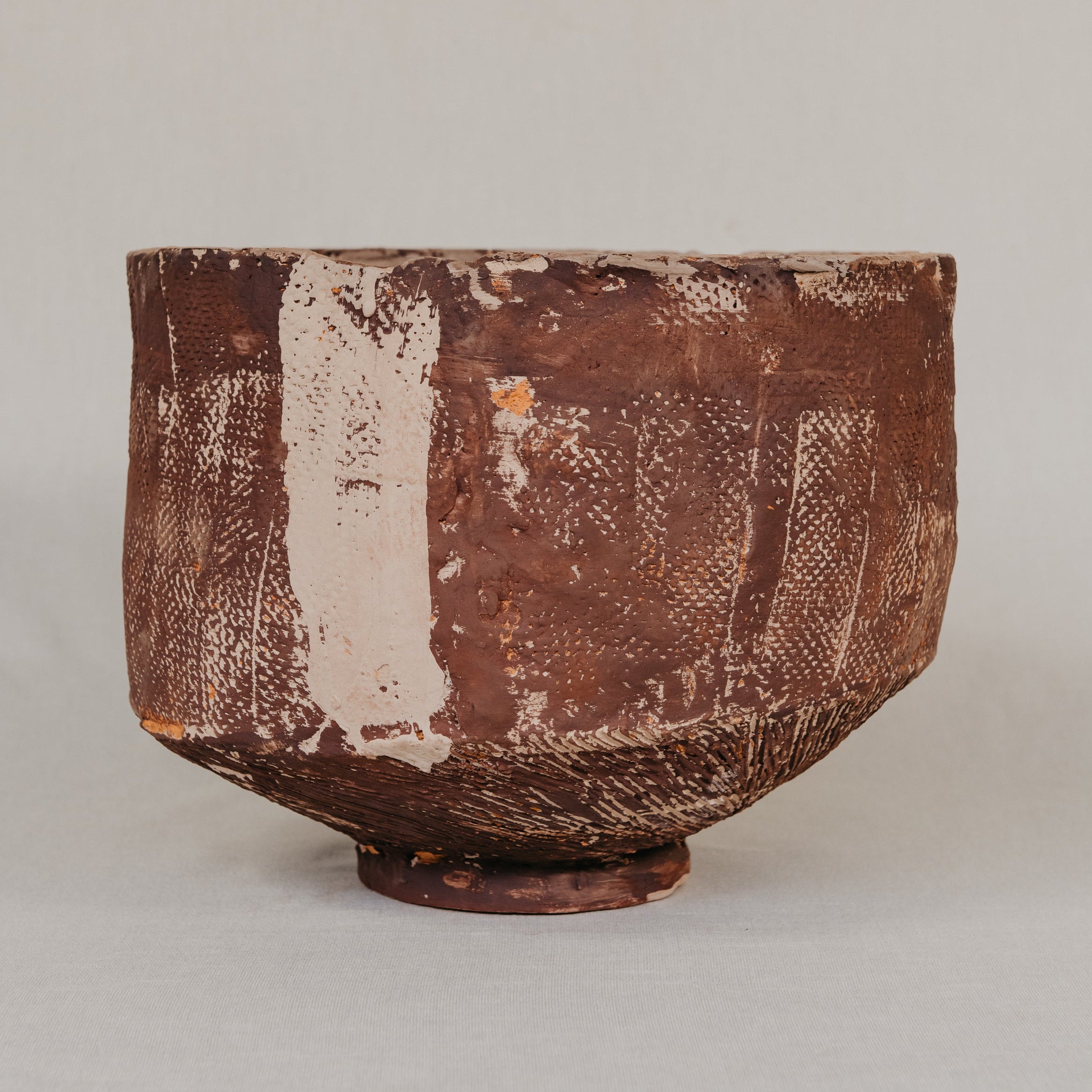 Close-up of a textured ceramic bowl on a neutral background