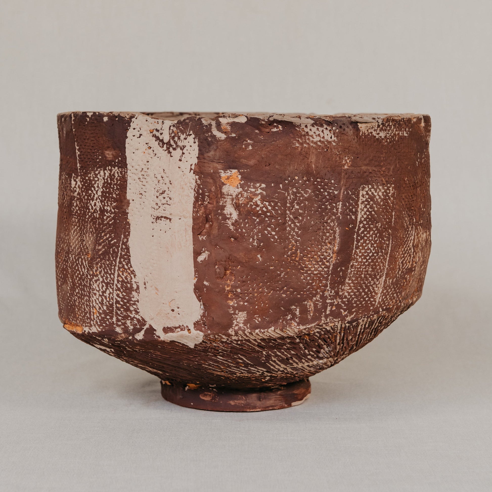 Close-up of a textured ceramic bowl on a neutral background