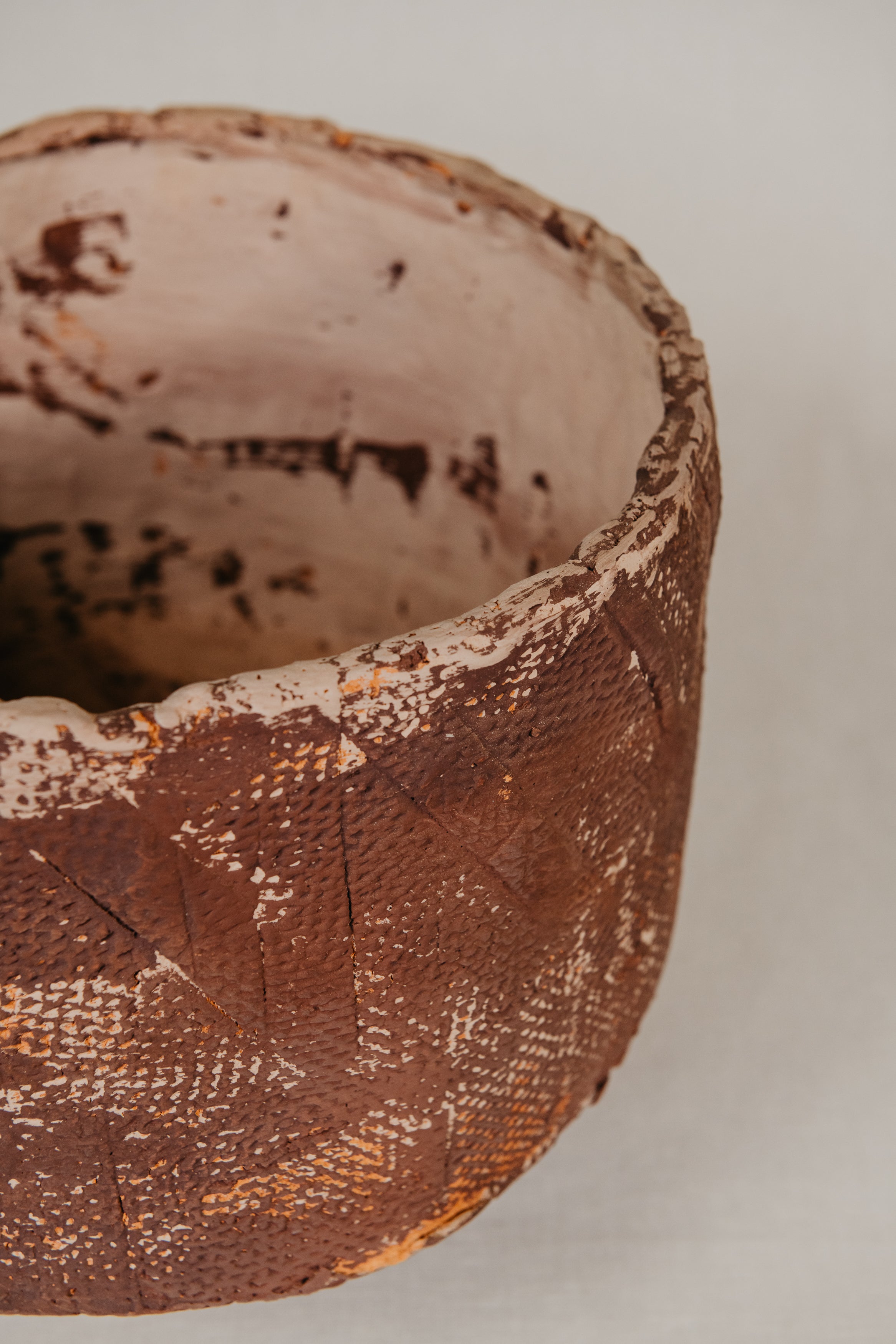 Close-up of a textured ceramic bowl on a neutral background