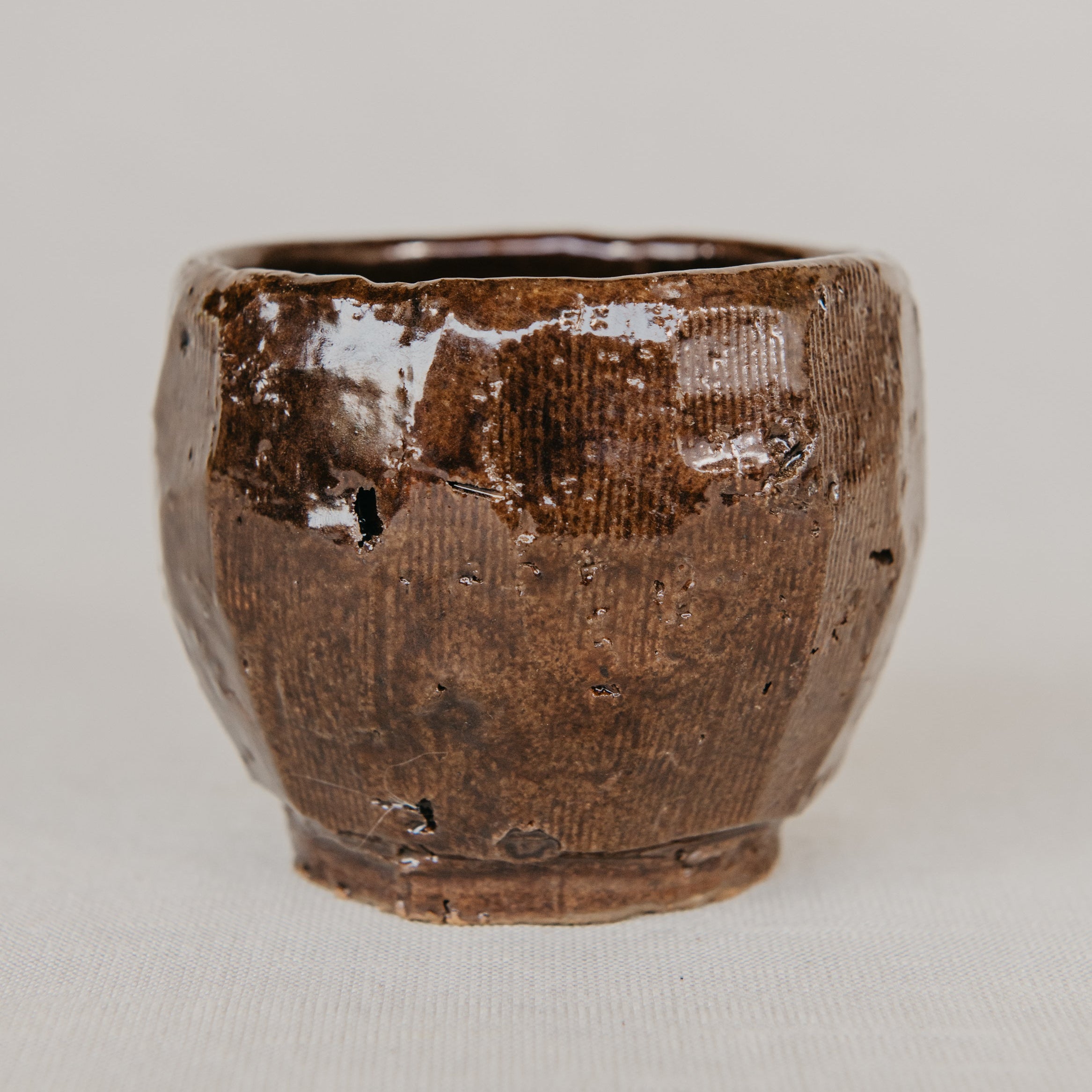Brown ceramic cup on a light gray background
