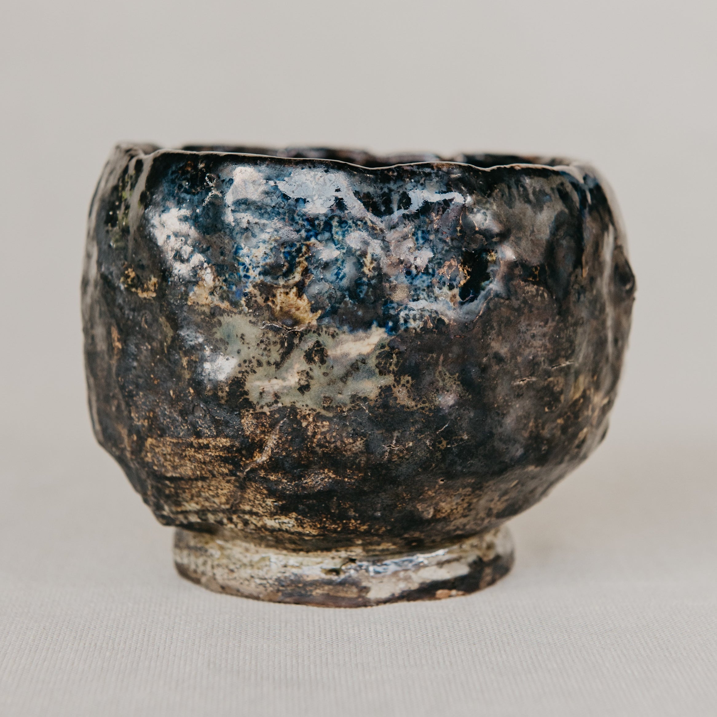 Black ceramic bowl with textured surface on a light gray background