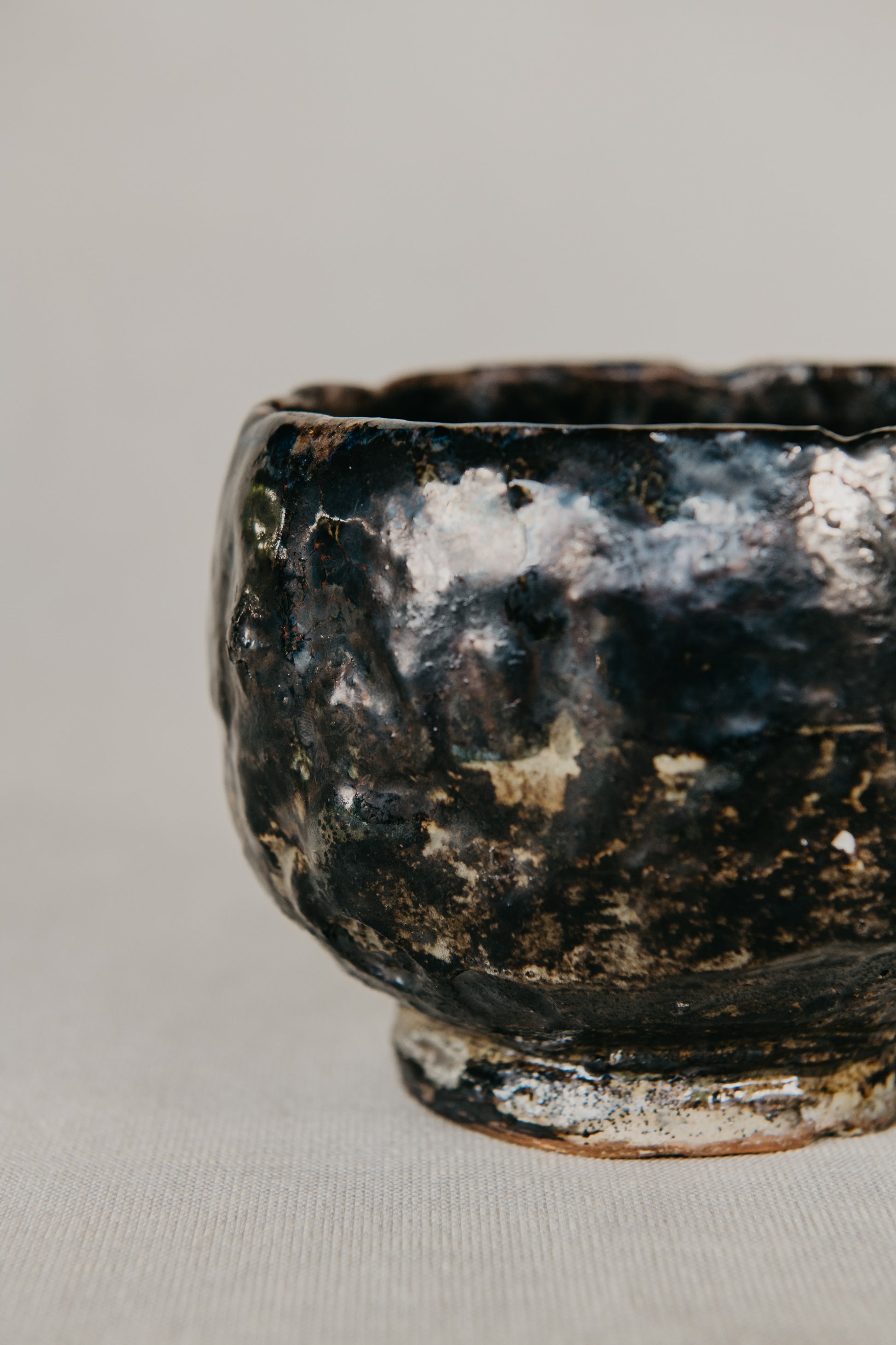 Black ceramic bowl with a textured surface on a light gray background