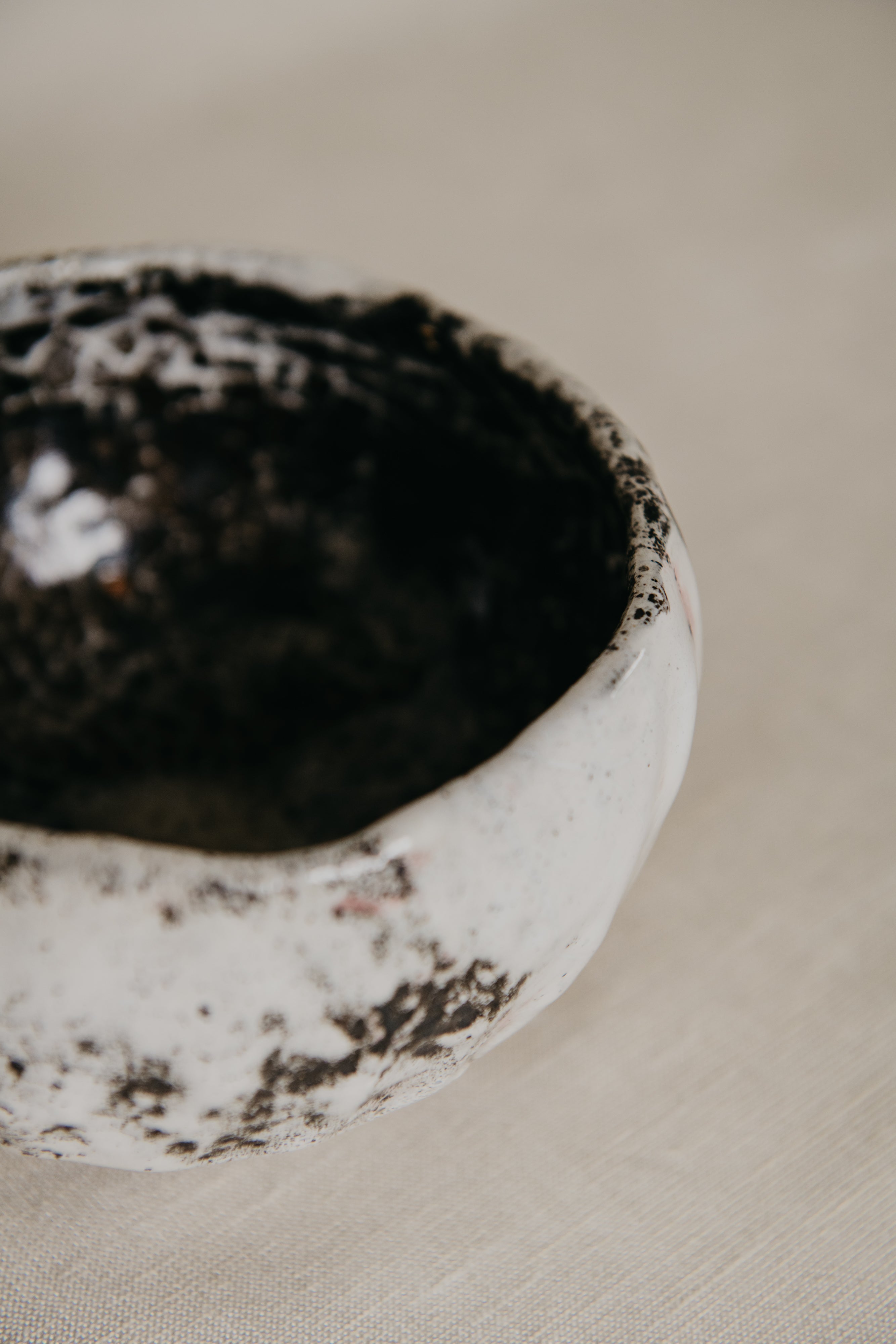 Close-up of a ceramic bowl with textured surface on a beige background