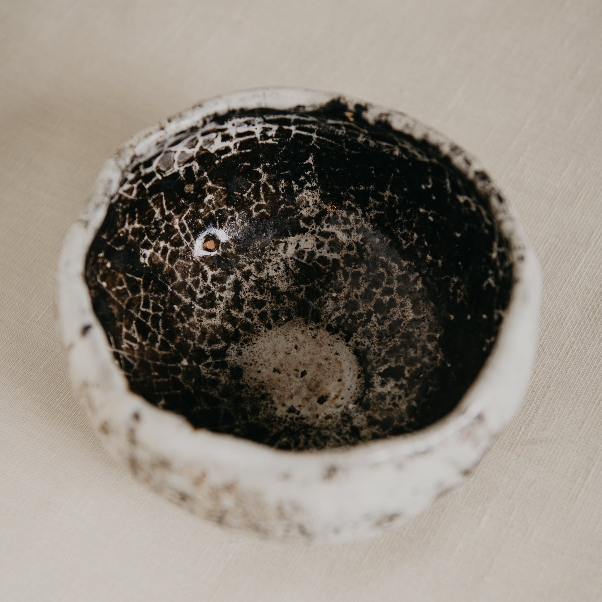 Close-up of a cracked ceramic bowl on a beige background