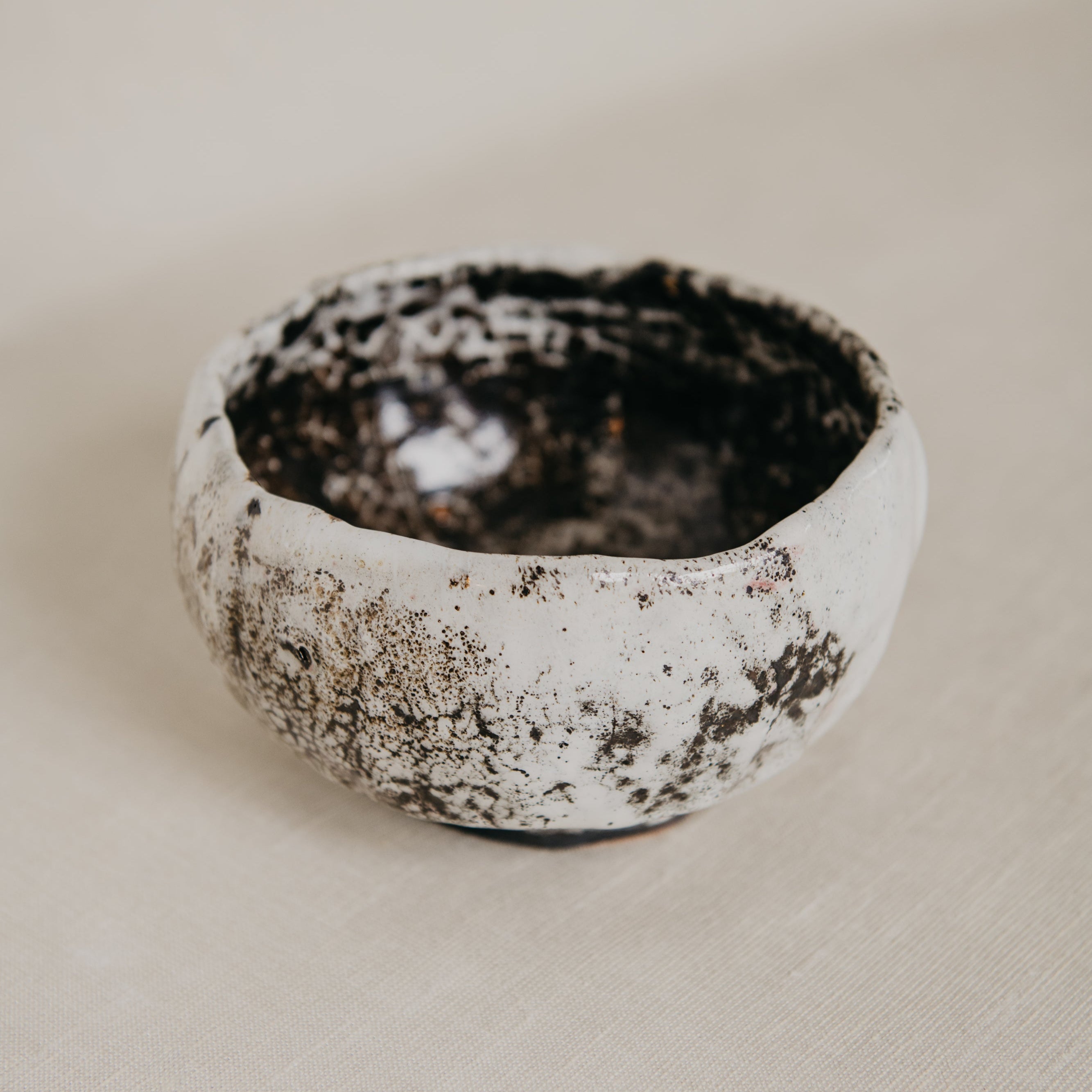 Small ceramic bowl with textured surface on a beige background