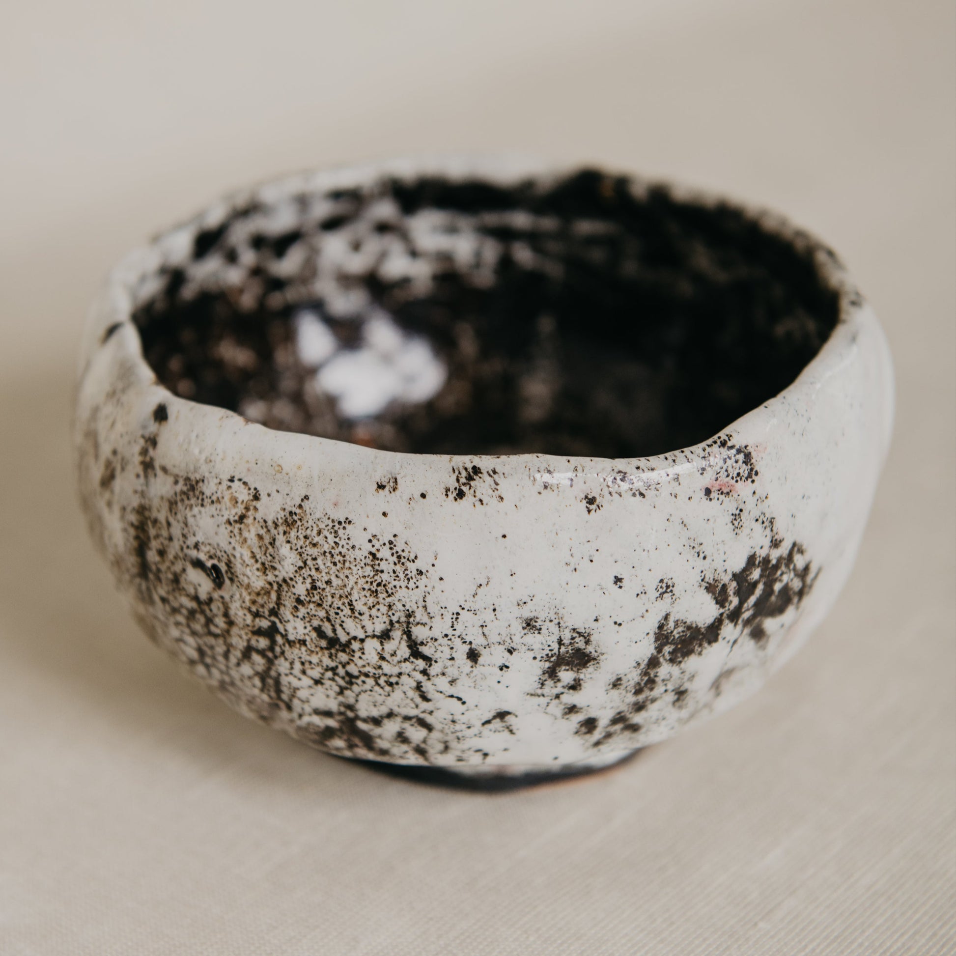 Small ceramic bowl with textured surface on a beige background