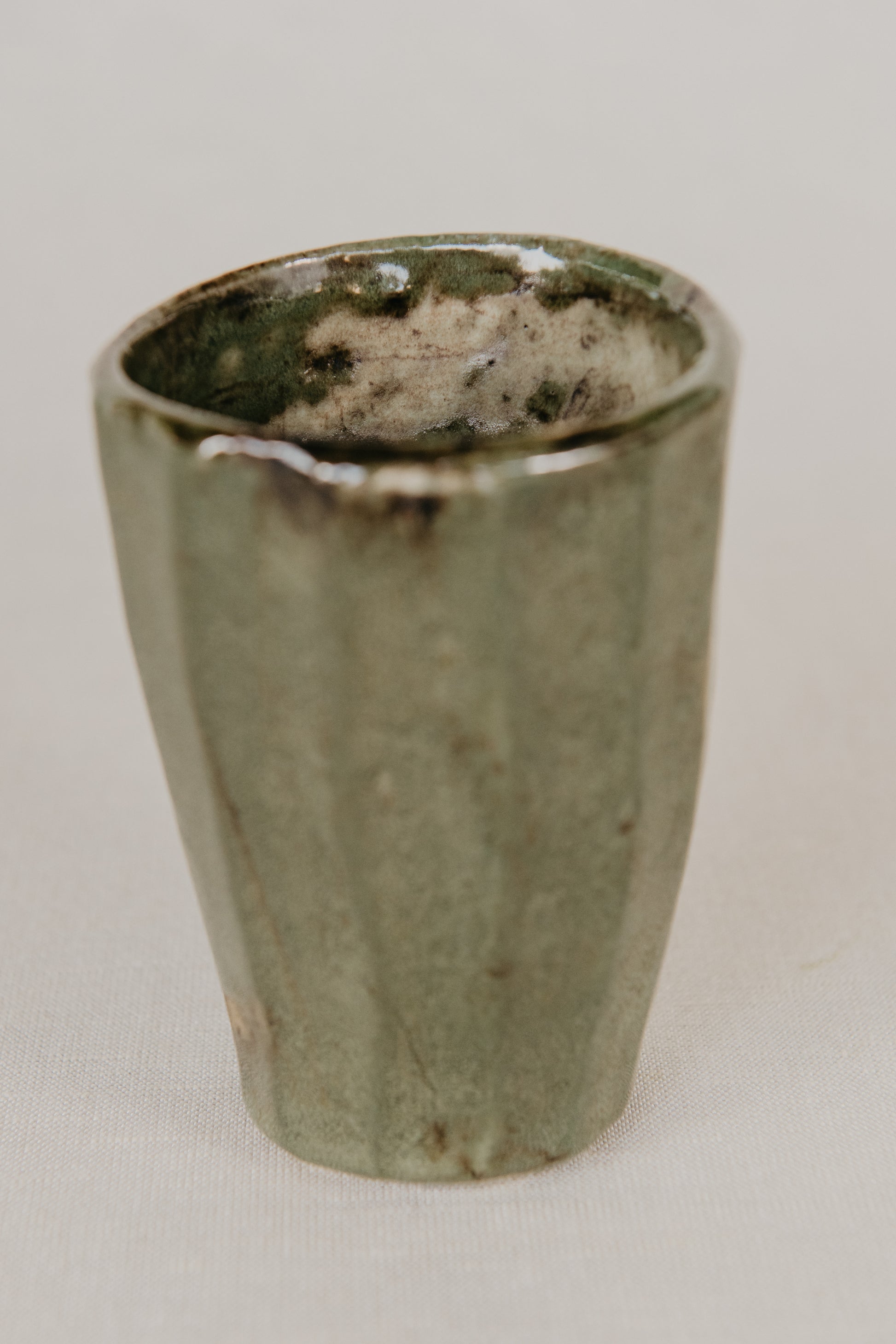 Green ceramic cup on a light gray background