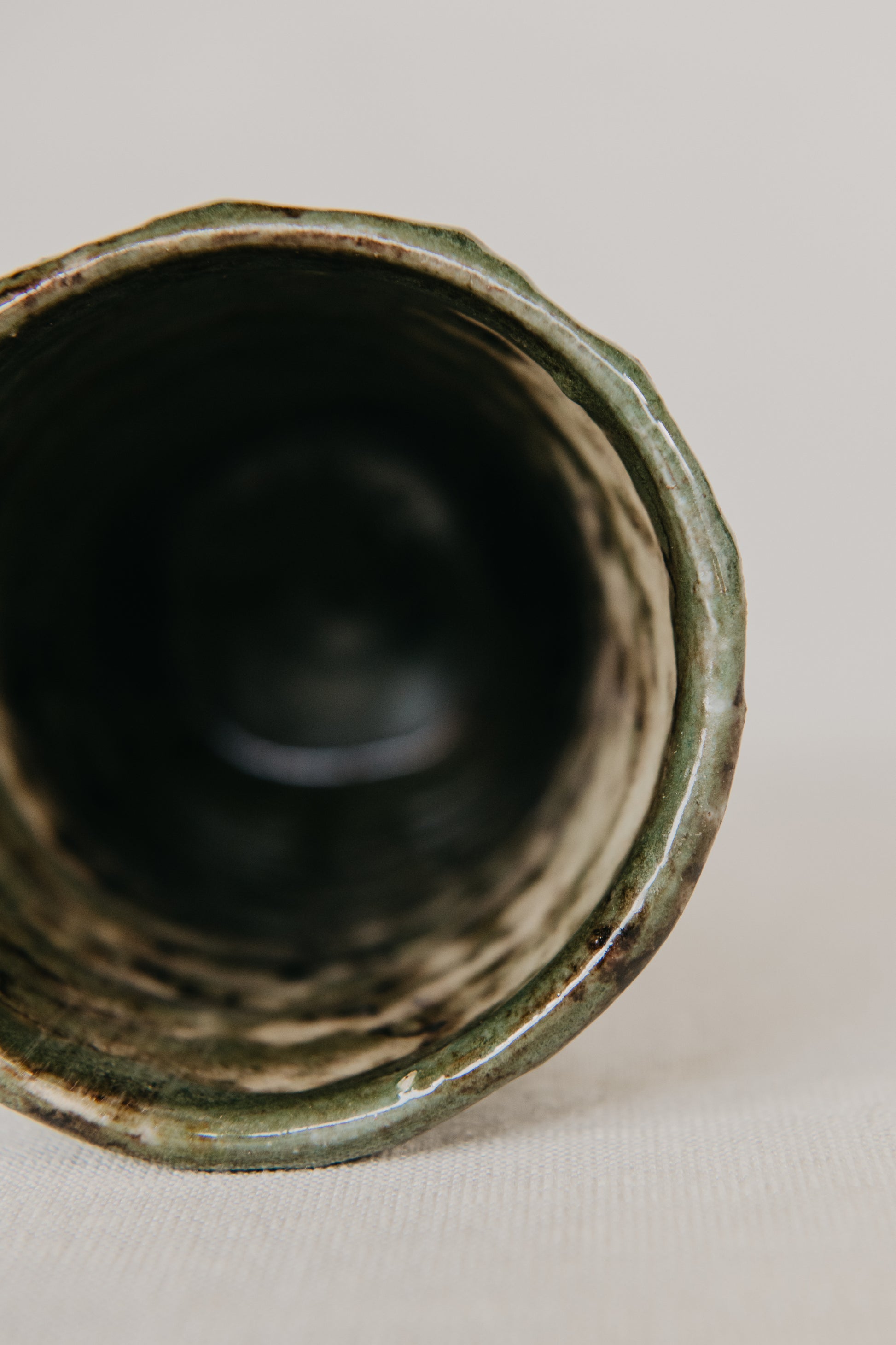 Close-up of a green ceramic vase on a light background