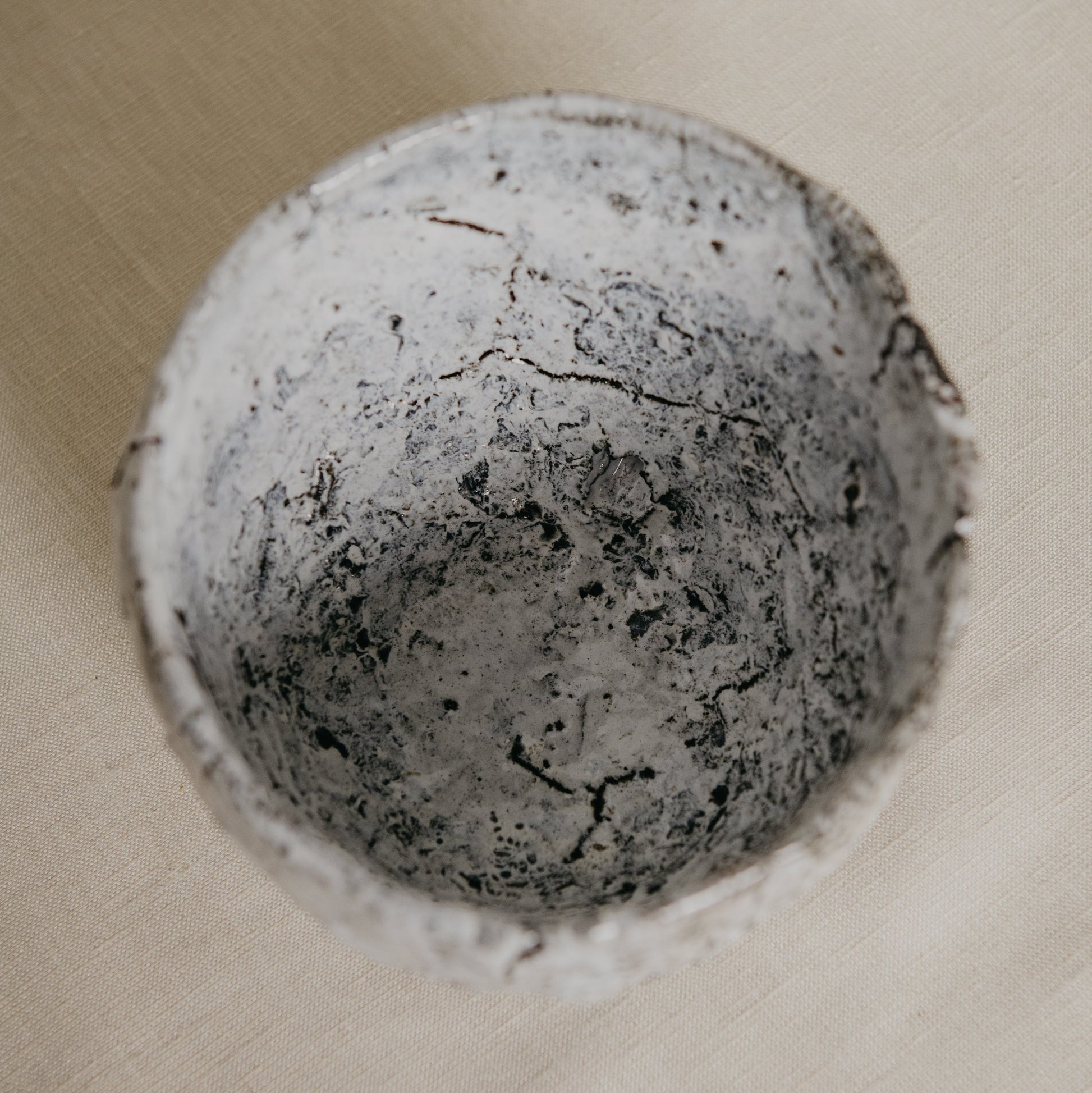 Close-up of a textured stone sphere on a beige background