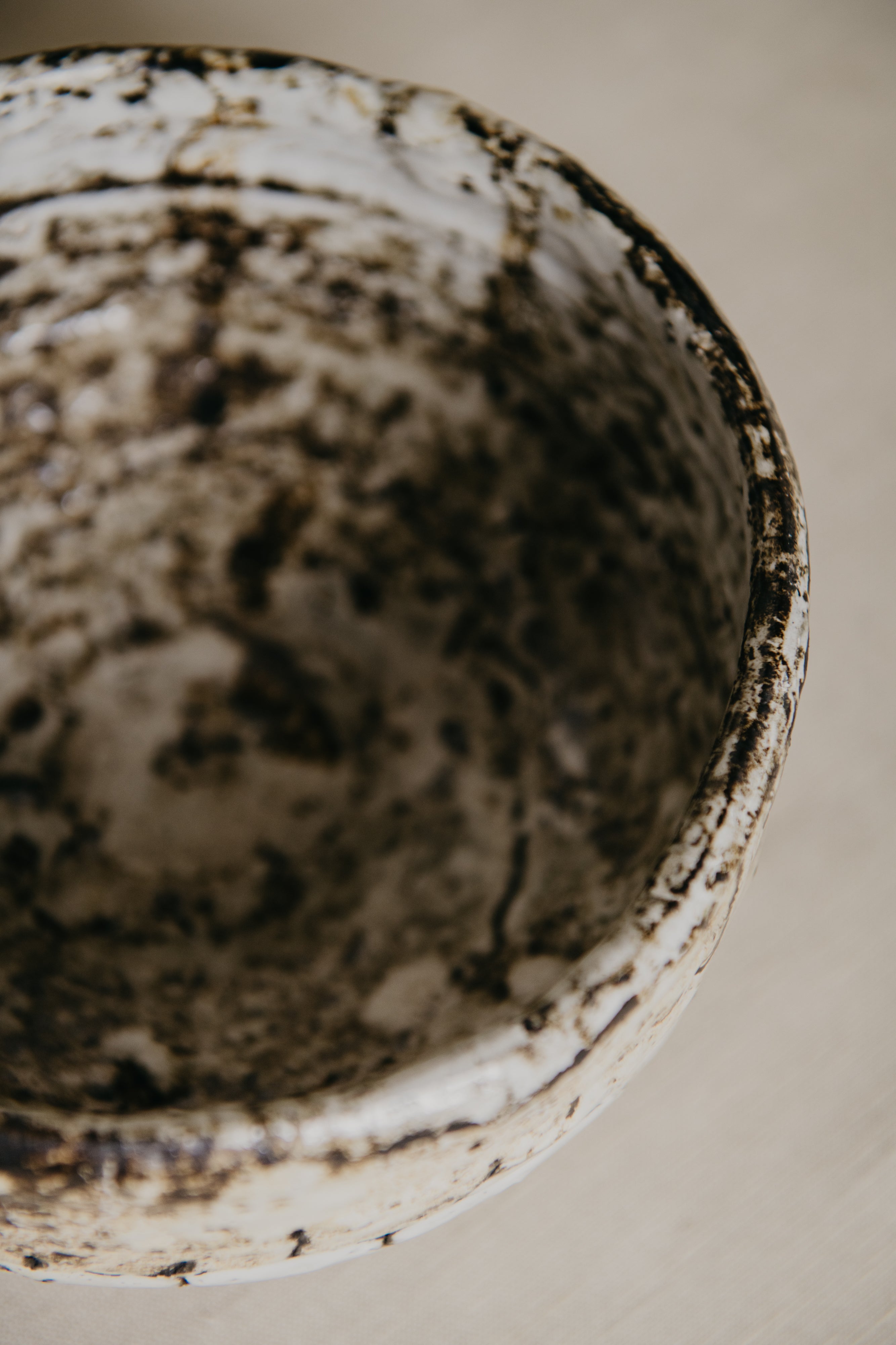 Close-up of a ceramic bowl with a textured surface on a neutral background