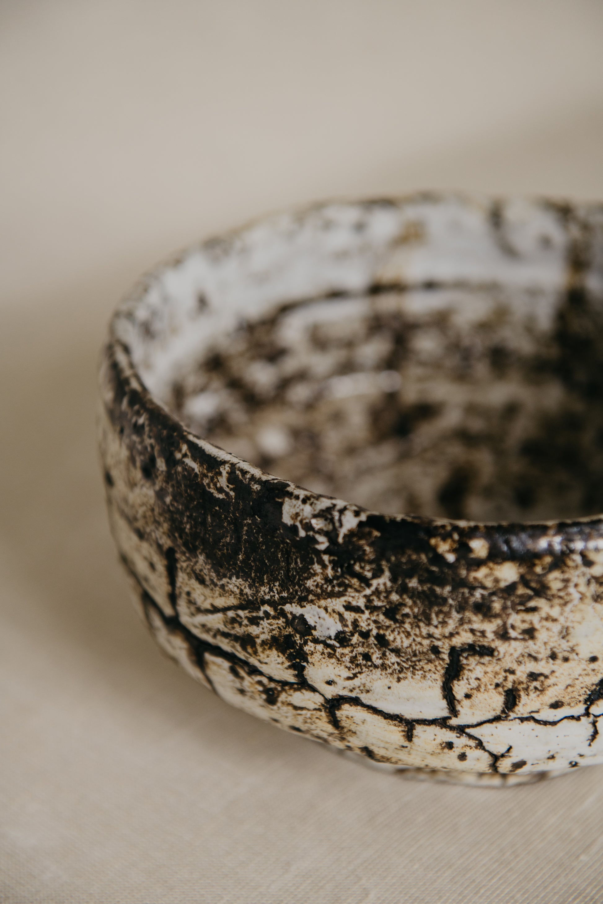 Close-up of a textured ceramic bowl on a neutral background