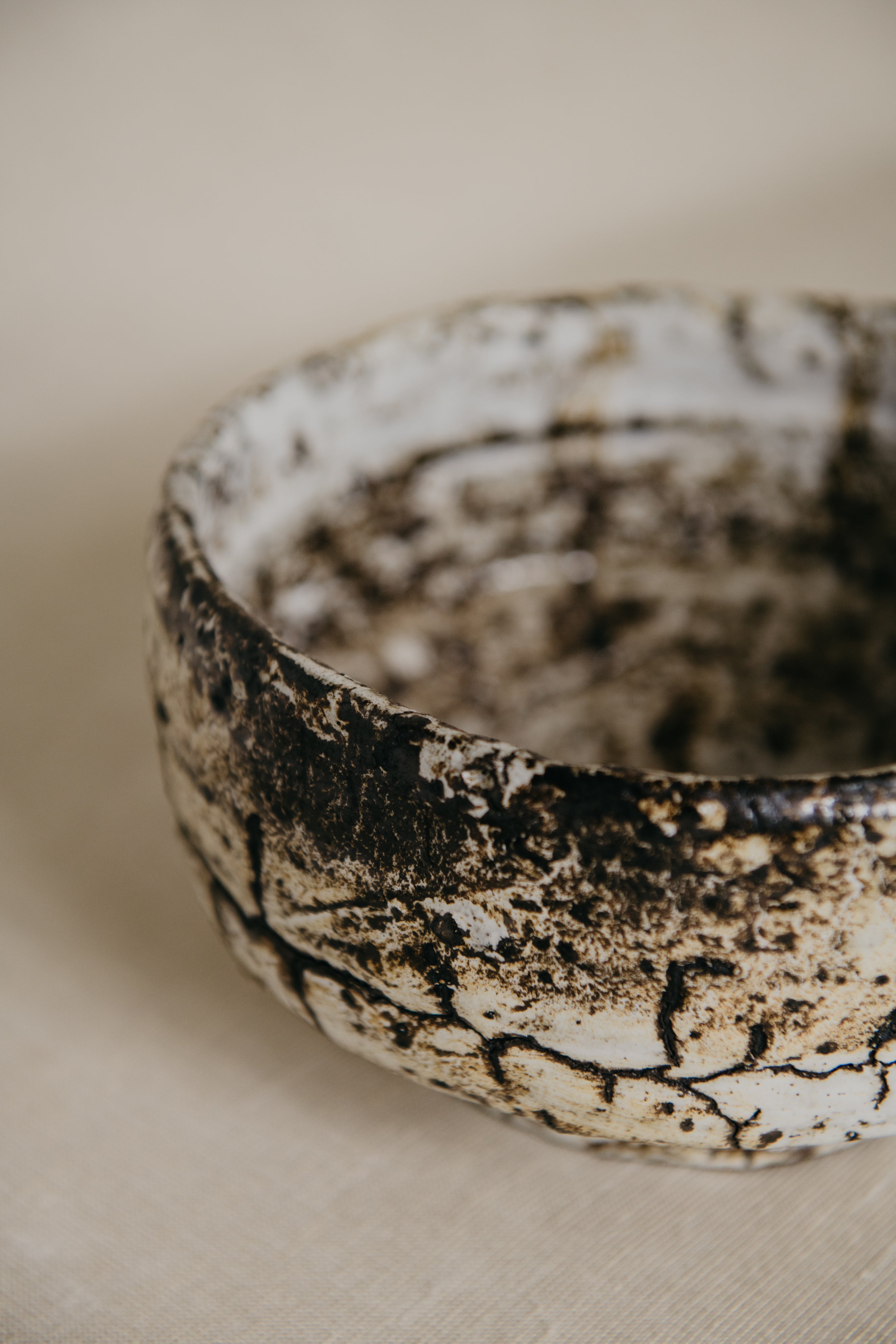Close-up of a textured ceramic bowl on a neutral background