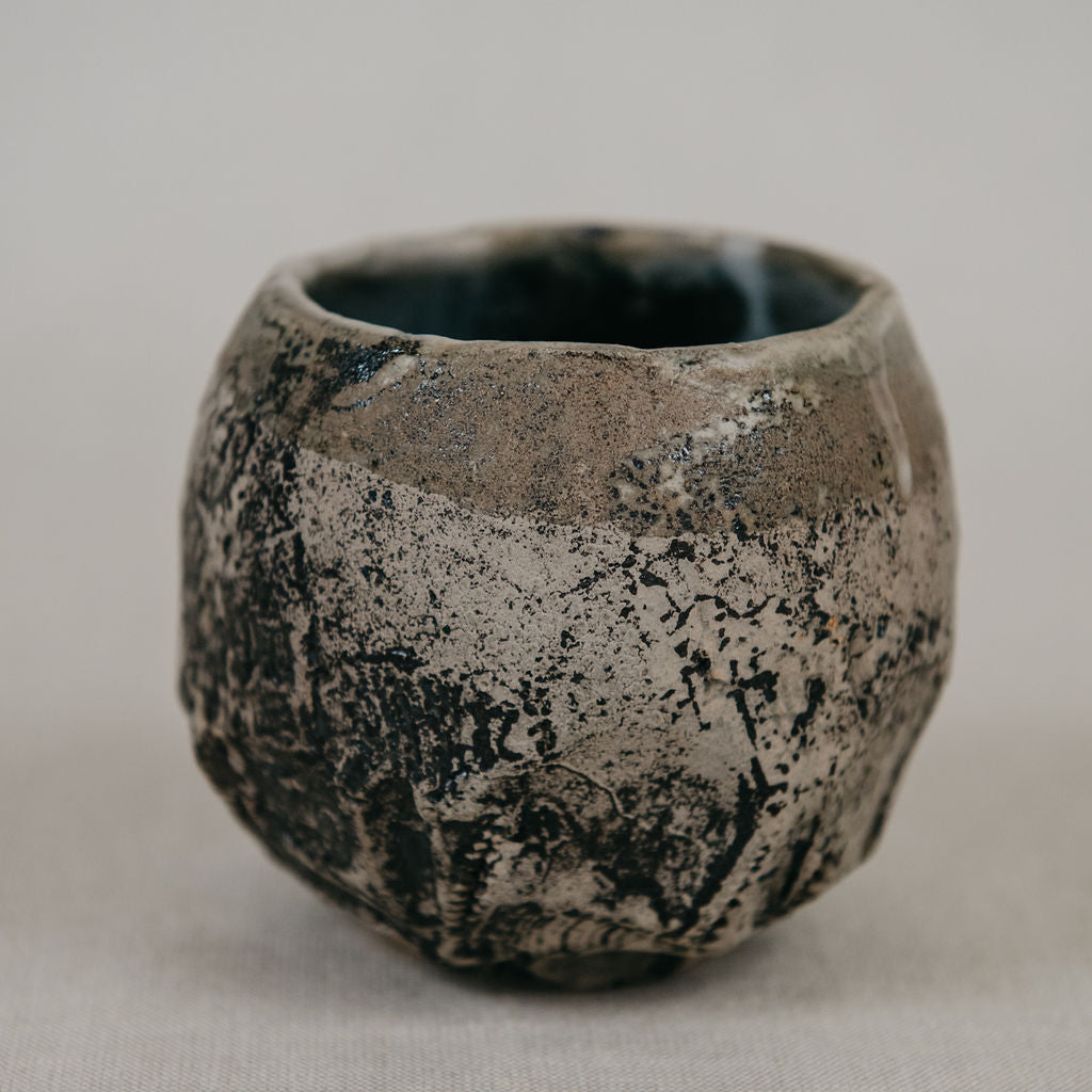 Ceramic cup with textured surface on a plain background